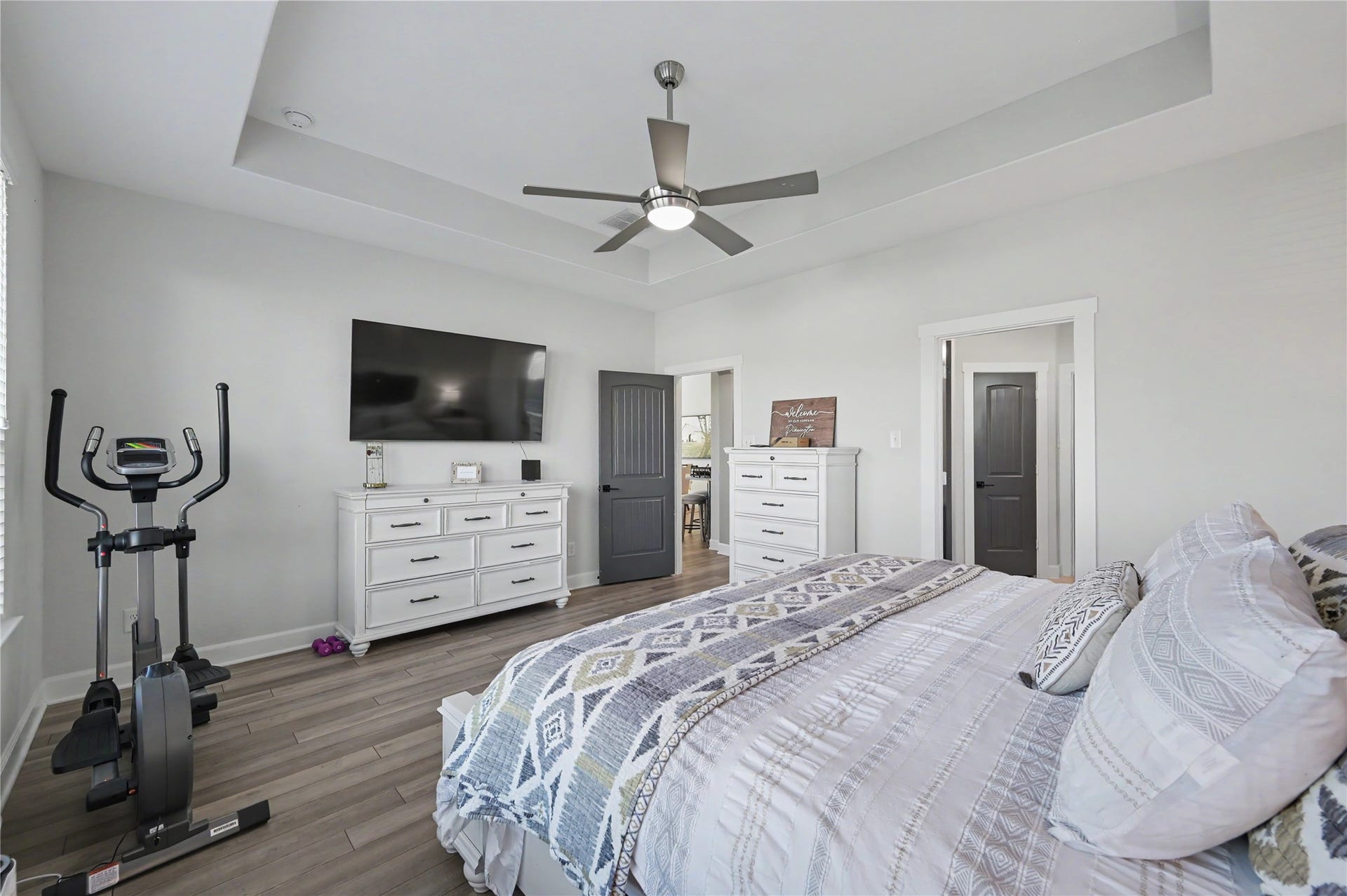 Another inviting view of the primary suite highlights its spacious design, elegant ceiling details, and comfortable layout. Neutral finishes and abundant natural light create a peaceful retreat to unwind at the end of the day.