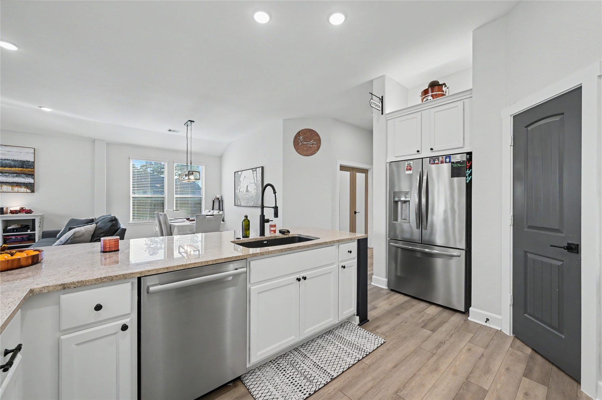 Another wonderful view of the kitchen highlights the stainless steel appliances, generous counter space, and plentiful cabinetry. The thoughtful layout offers excellent functionality for everyday cooking while maintaining a bright, modern, and inviting atmosphere.