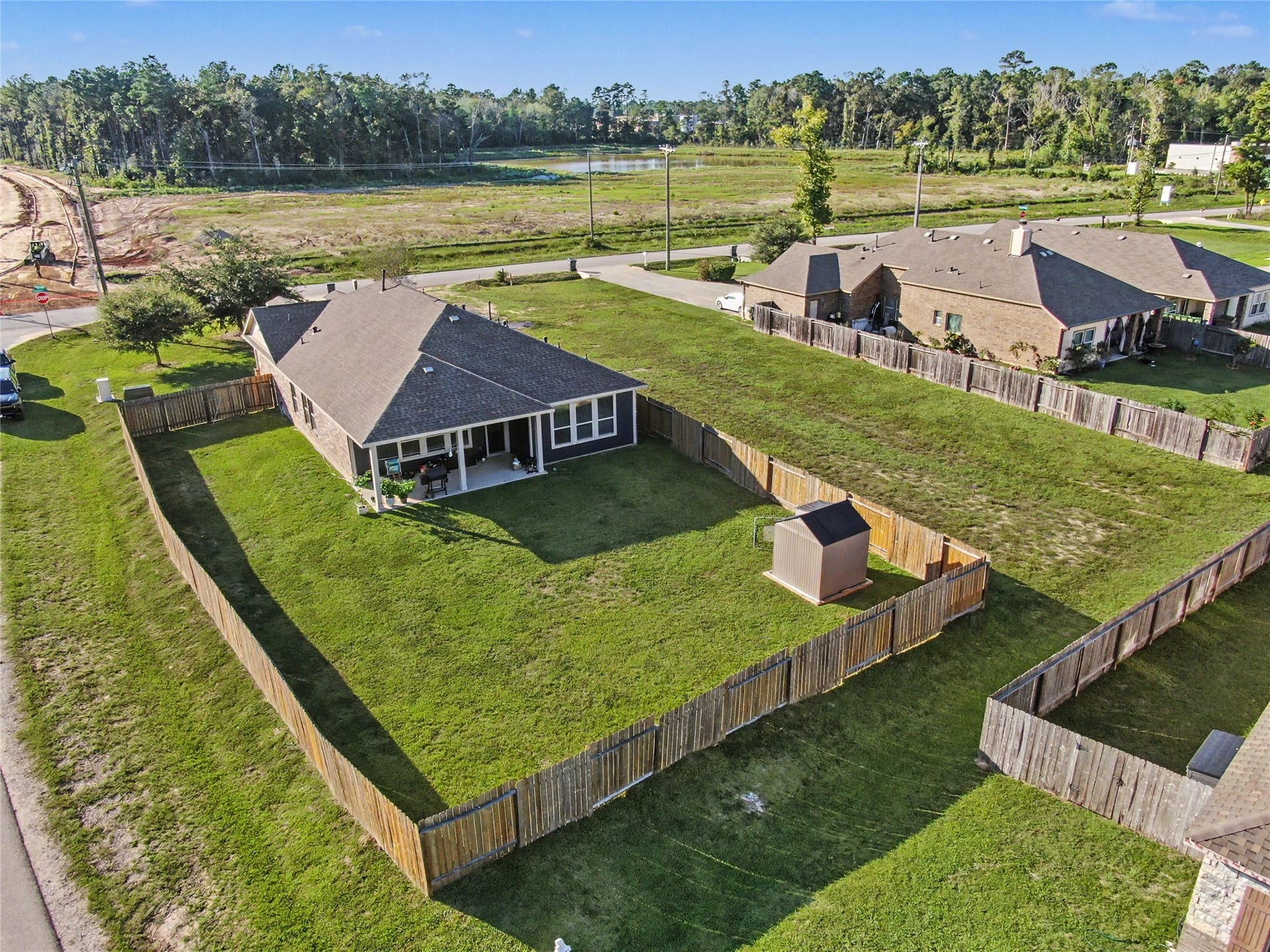 This elevated perspective beautifully showcases the home's spacious backyard and extra lot. With a large grassy lawn and plenty of open space, the property offers wonderful opportunities for outdoor enjoyment and entertaining.