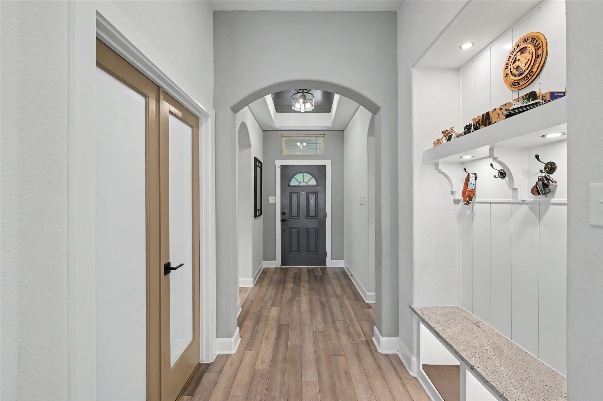 This inviting foyer showcases beautiful flooring, neutral finishes, and elegant architectural details. The bright hallway provides a seamless transition into the home's living spaces while maintaining a clean and sophisticated feel.