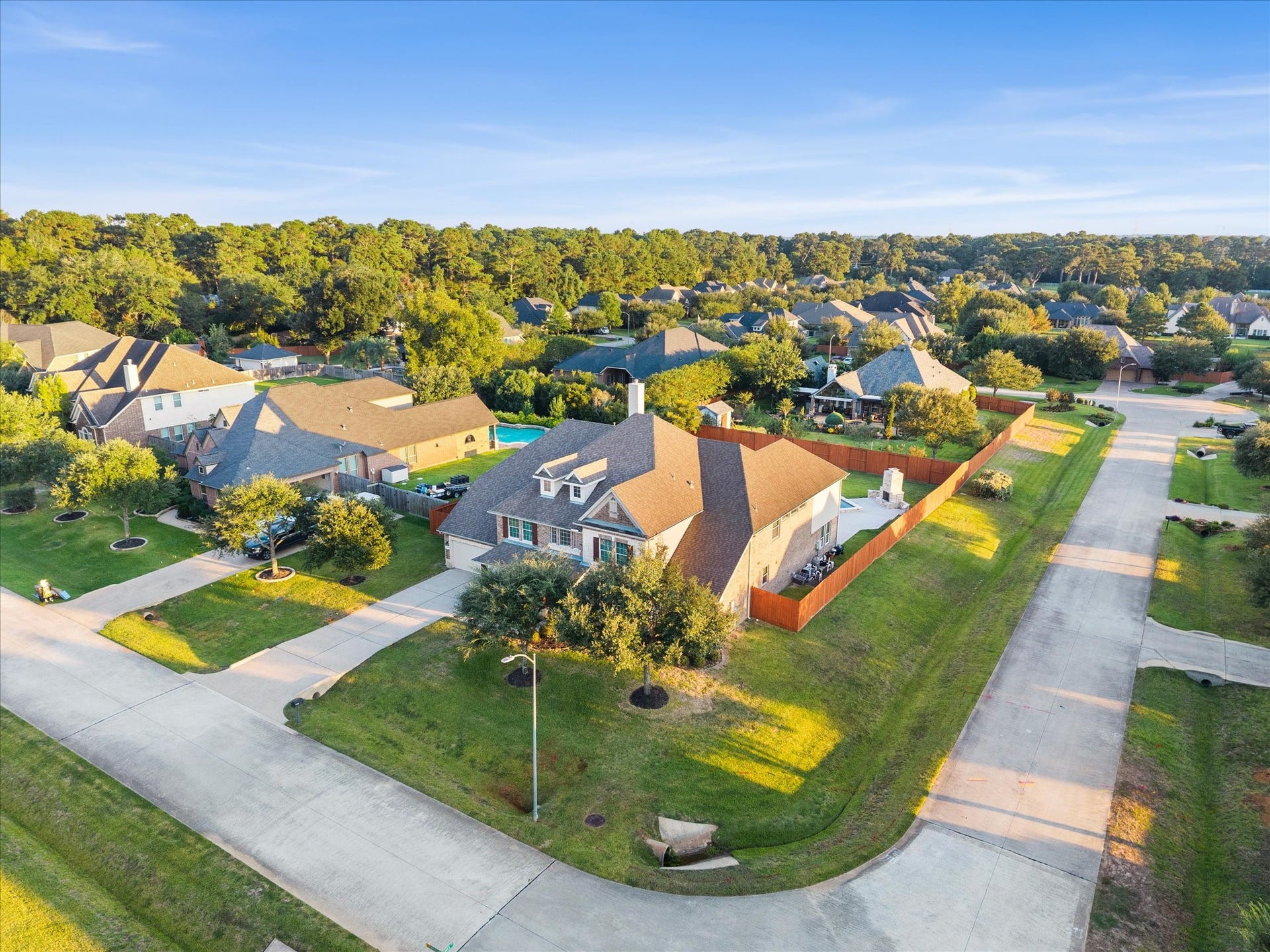 10458 Waterstone Estates Court, Tomball, TX 77375 An aerial perspective captures the home's impressive presence on an oversized corner lot along a cul-de-sac street, showcasing the scale of this beautiful property within gated Waterstone Estates.