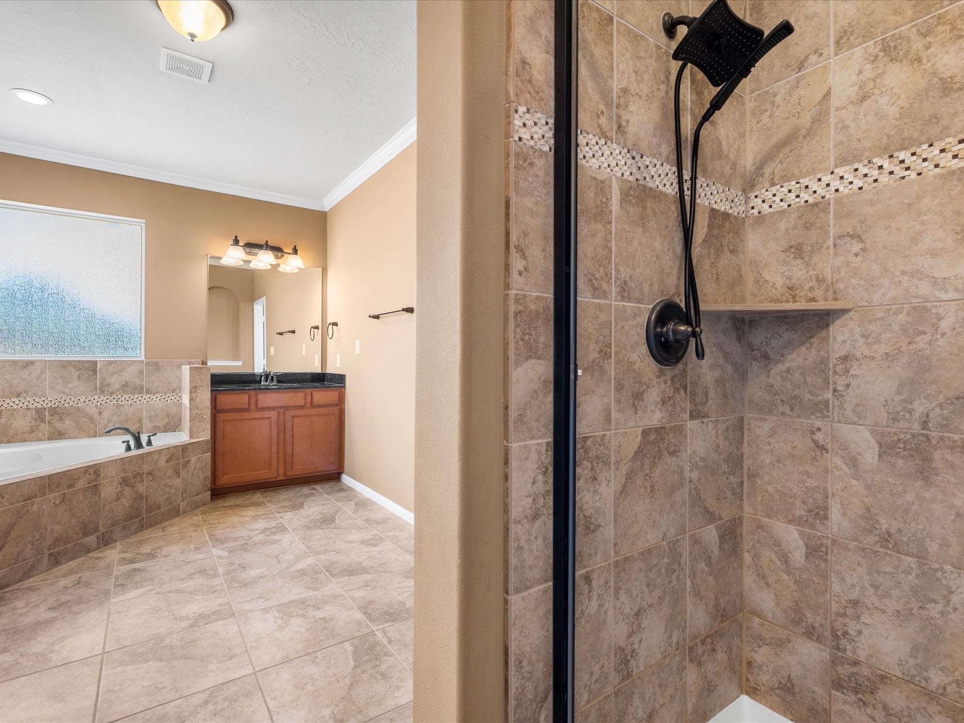 10458 Waterstone Estates Court, Tomball, TX 77375 A separate walk-in shower adds everyday convenience to the expansive primary ensuite.