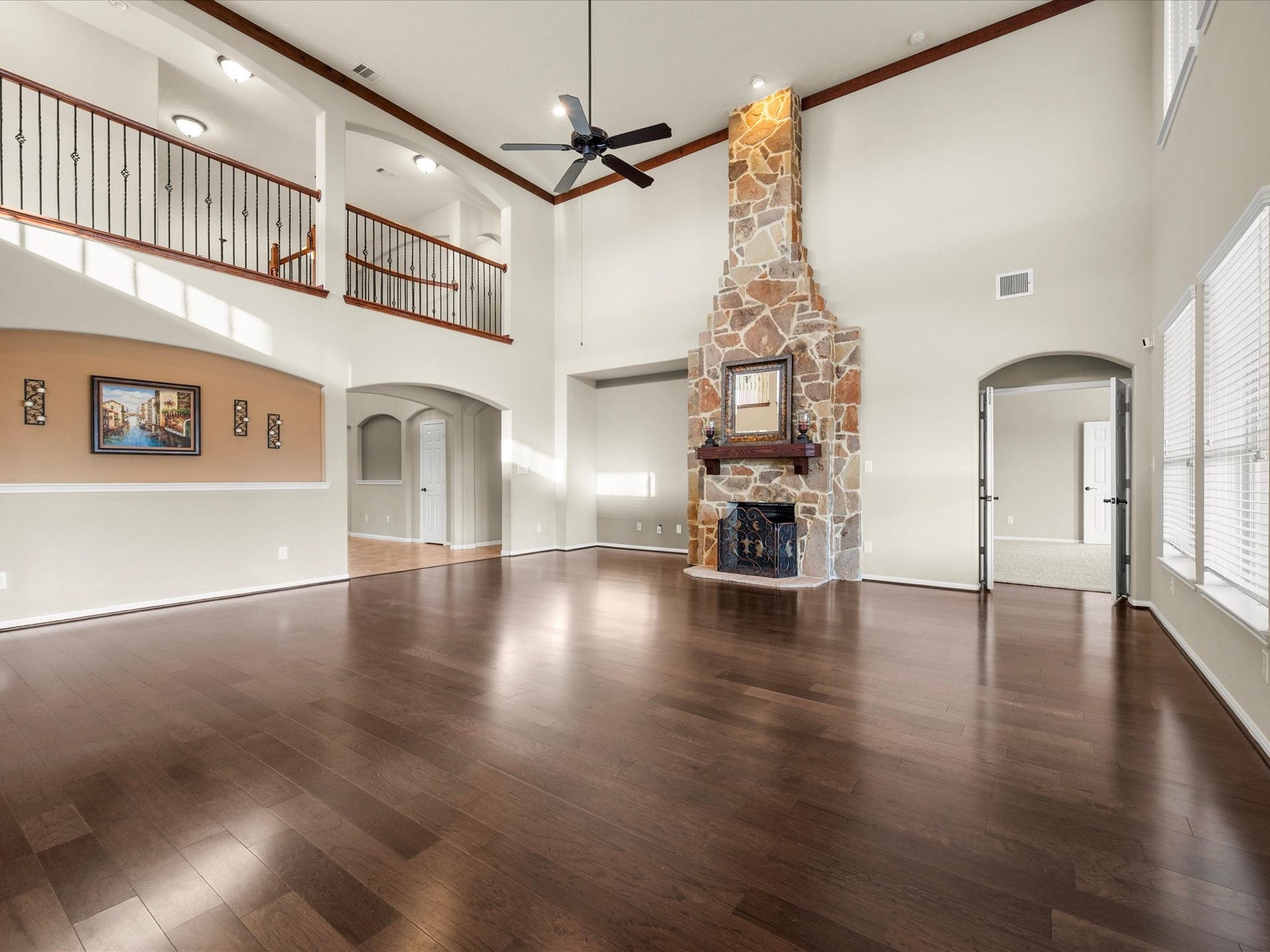 10458 Waterstone Estates Court, Tomball, TX 77375 The floor-to-ceiling stone fireplace draws the eye upward to the beautiful second-story balcony, while the adjoining primary suite offers convenient access just off the living room.