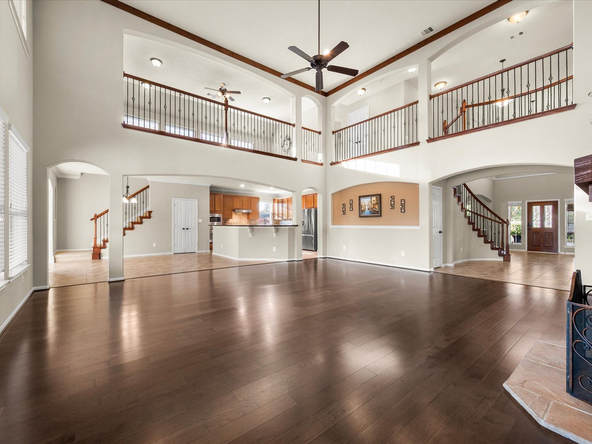 10458 Waterstone Estates Court, Tomball, TX 77375 Soaring ceilings and beautiful wood floors emphasize the impressive scale of this meticulously maintained living room, where natural light and the stone fireplace create a welcoming place to gather.