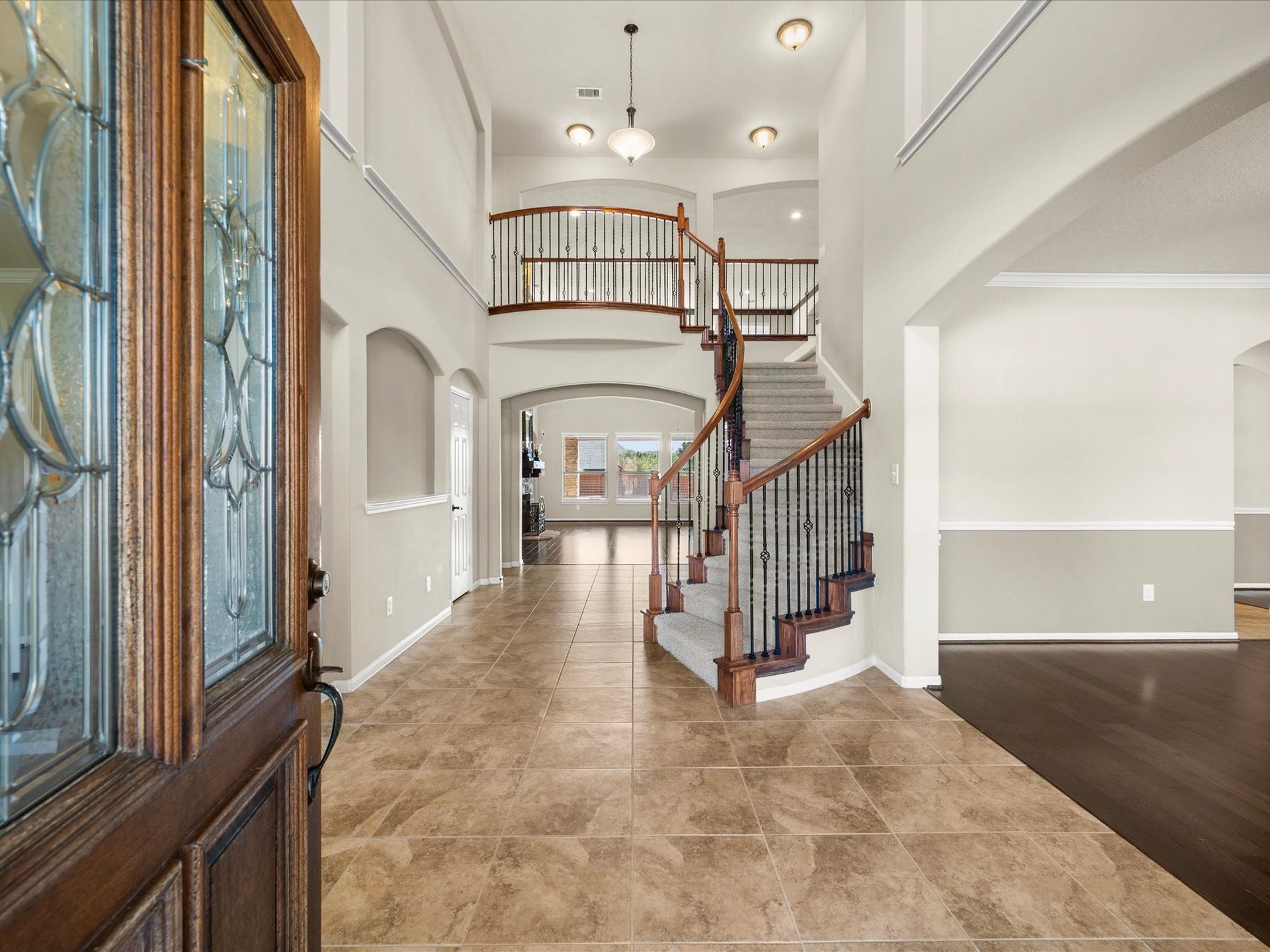 10458 Waterstone Estates Court, Tomball, TX 77375 A grand entryway, soaring ceilings, and a sweeping staircase with elegant iron balusters and wood treads establish an impressive sense of arrival, with expansive living spaces unfolding beyond.