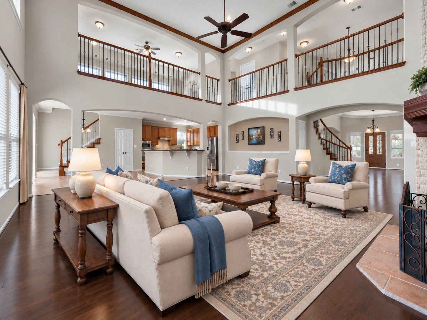 10458 Waterstone Estates Court, Tomball, TX 77375 Virtually staged to illustrate its grand scale, the dramatic 2-story living room features soaring ceilings, rich wood-toned crown molding, a striking stone fireplace, and a balcony overlooking the space.