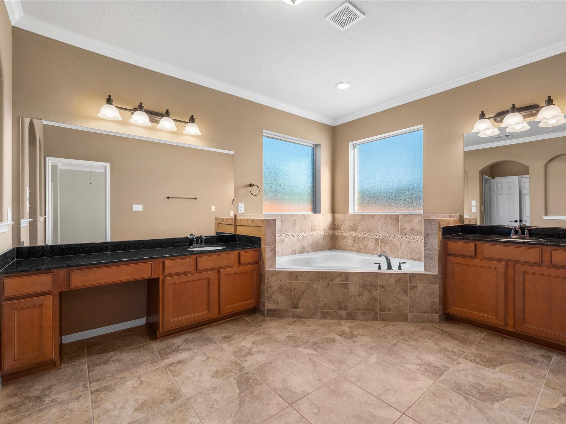 10458 Waterstone Estates Court, Tomball, TX 77375 Designed for comfort and relaxation, the spacious primary ensuite features dual vanities, a jetted soaking tub, and a separate walk-in shower.