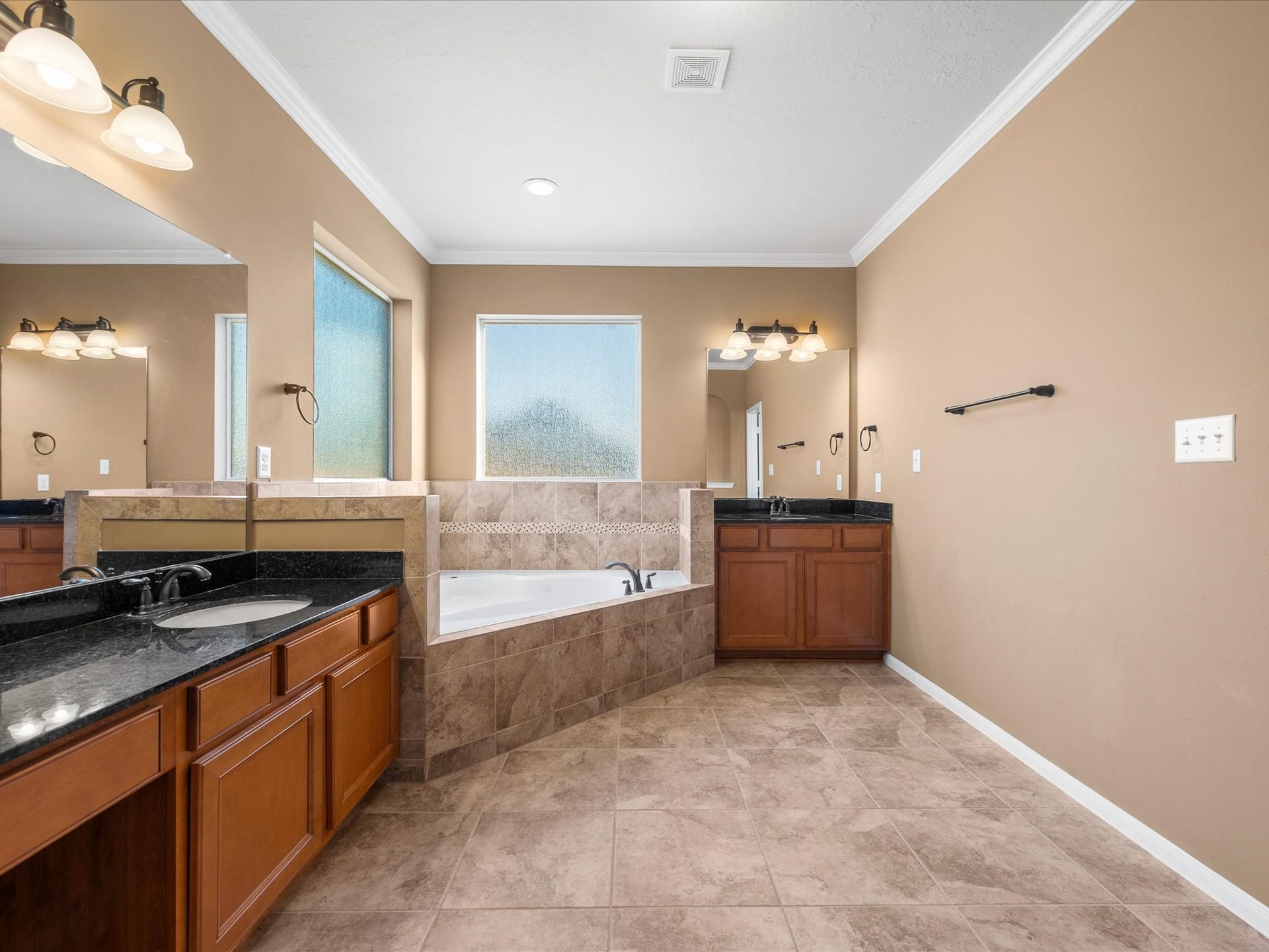 10458 Waterstone Estates Court, Tomball, TX 77375 Natural light pours through the bathroom windows, brightening the spacious ensuite and enhancing its calm, inviting atmosphere.