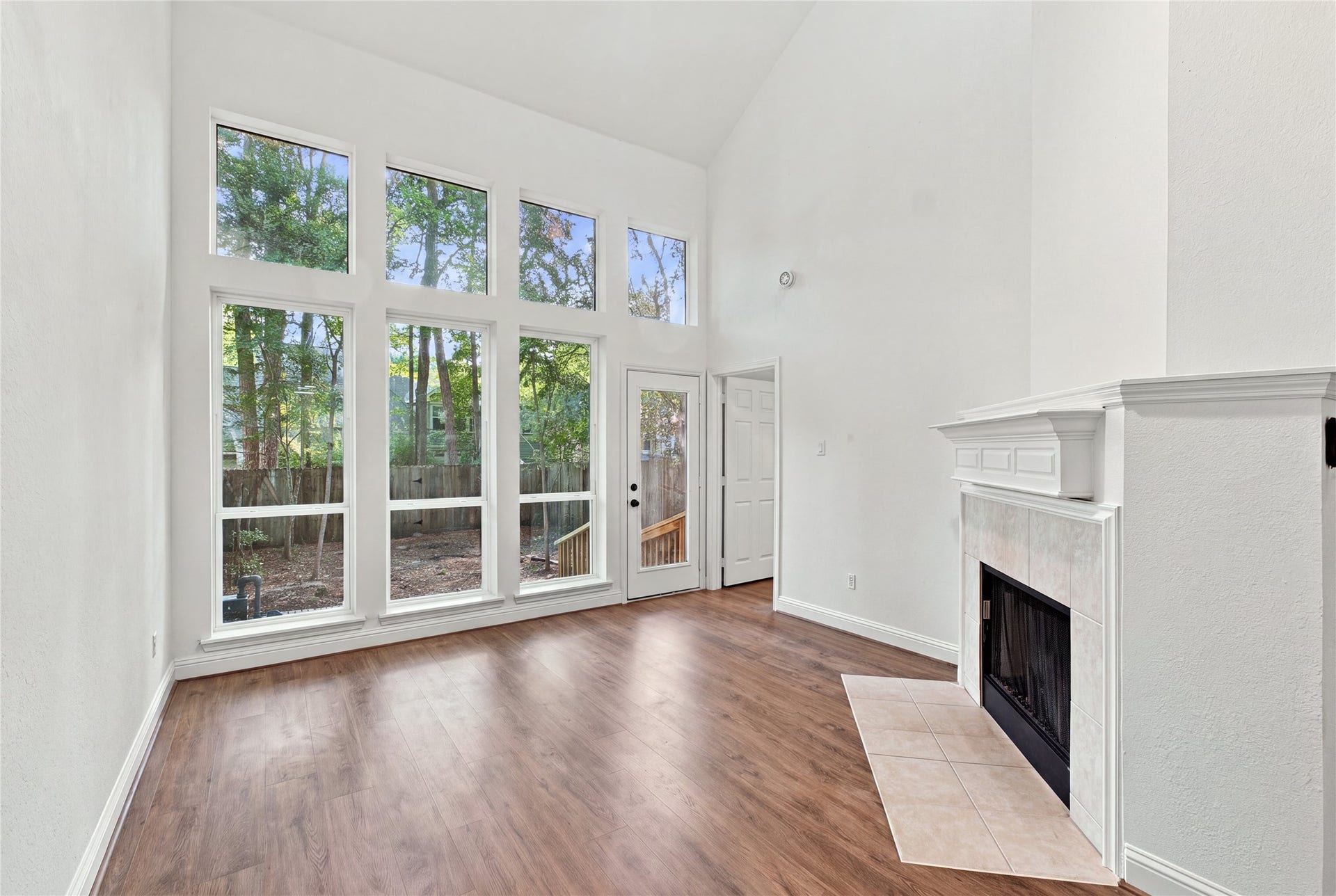 47 Alderon Woods Place, Spring, TX 77382 The living room features vaulted ceilings, a wall of windows, a fireplace and direct backyard access, creating a comfortable space to relax or entertain.