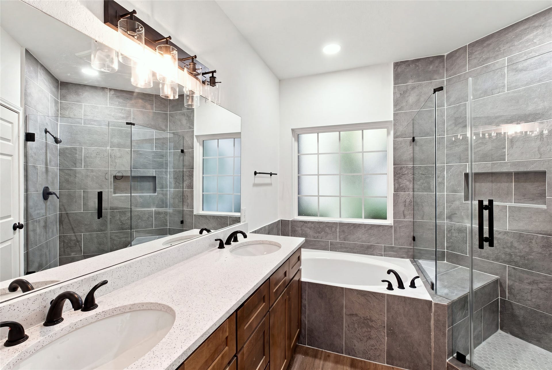 47 Alderon Woods Place, Spring, TX 77382 Updated primary en-suite with dual sinks, a soaking tub, frameless glass shower and modern black fixtures.