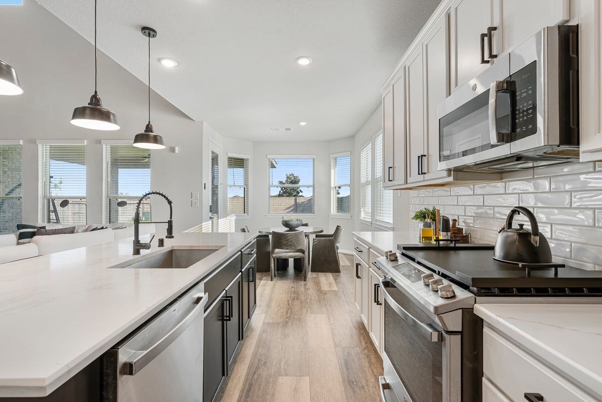 1702 Darwin Cedar Drive, Rosharon, TX 77583 The kitchen feels endless with upgraded quartz counters, two-toned cabinetry and stainless steel appliances!