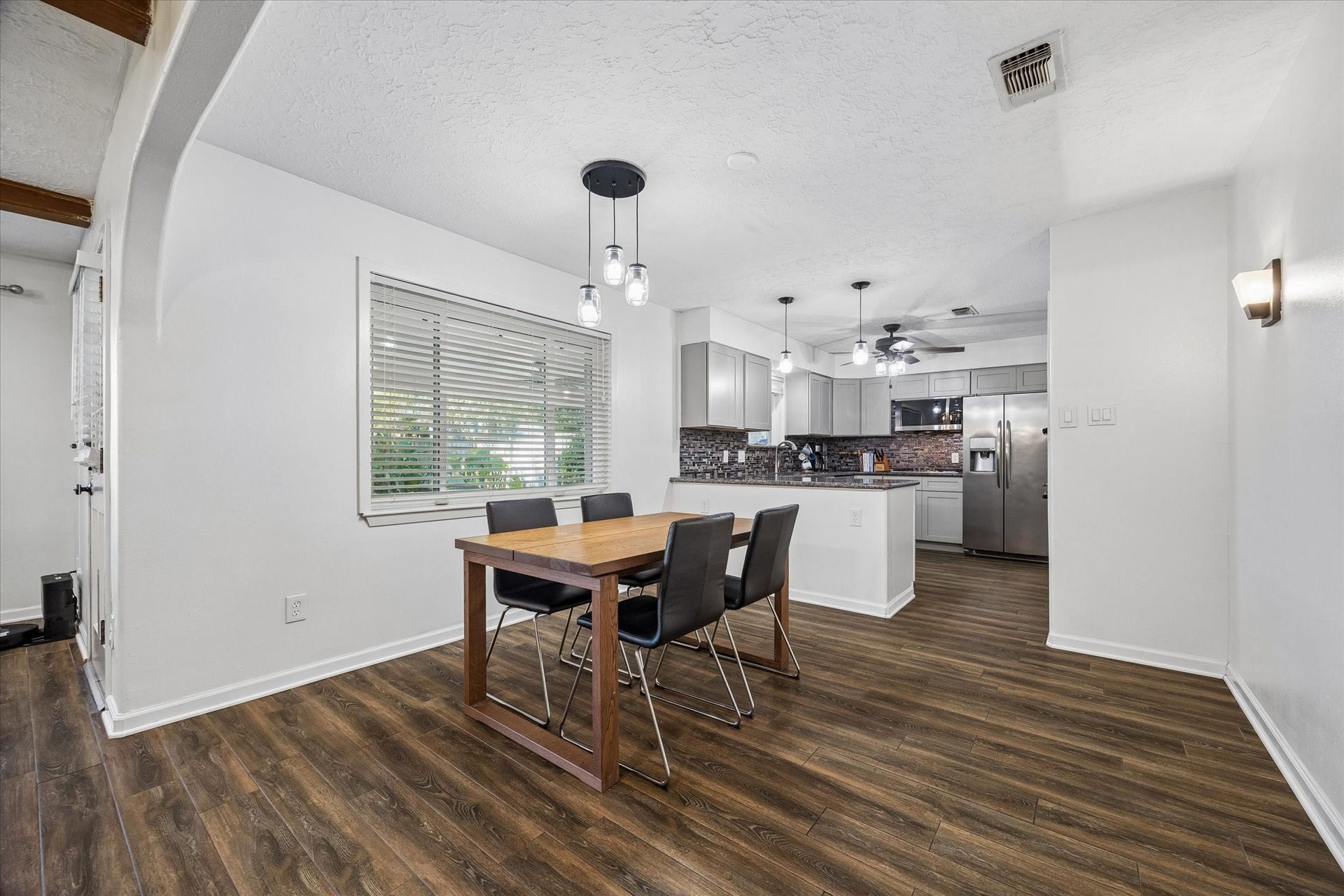 15726 Blackhawk Boulevard, Friendswood, TX 77546 View of formal dining room with designer lights, tile wood floor opening to the kitchen and family room.