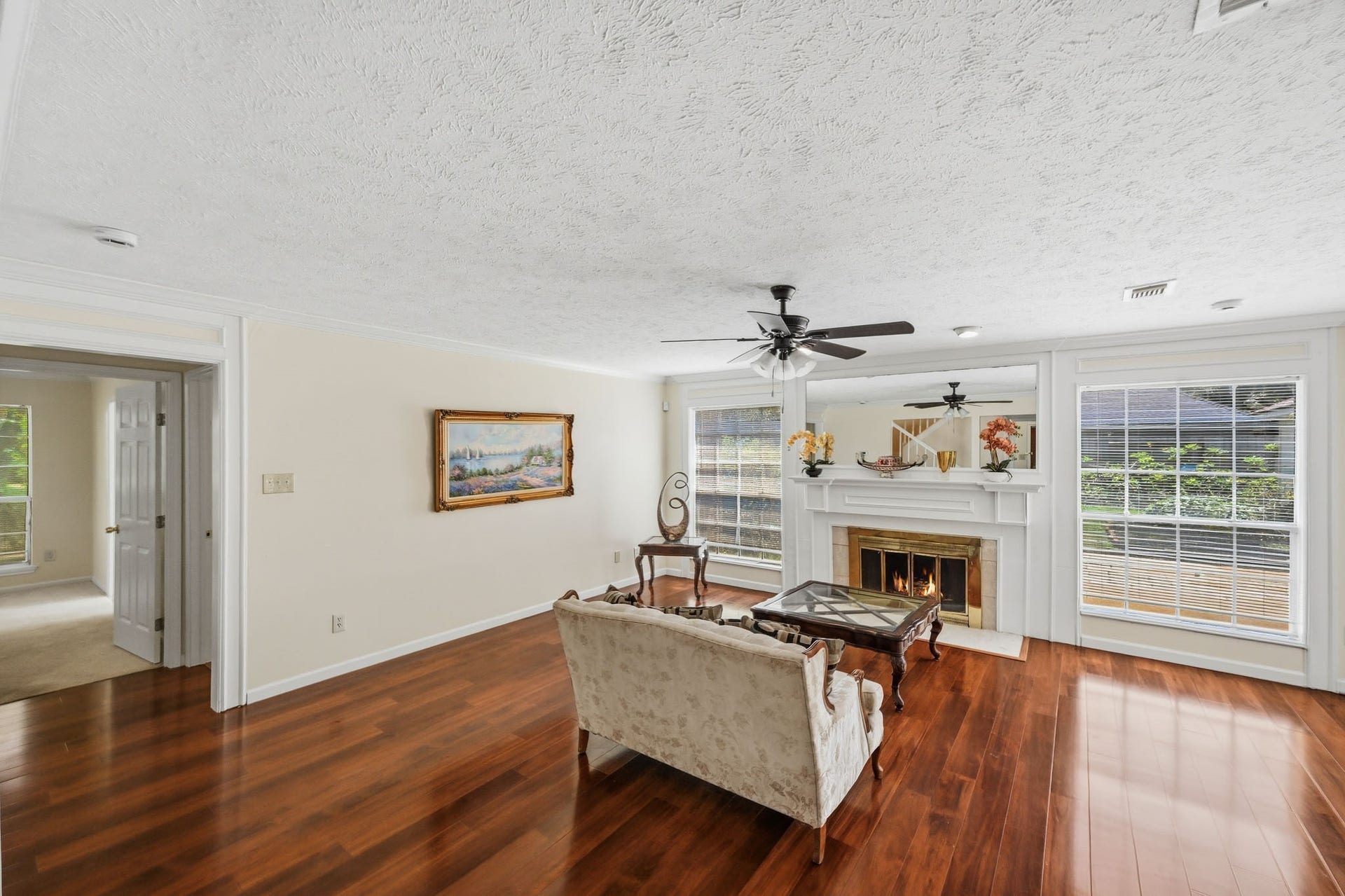 3926 Felicia Drive, Sugar Land, TX 77479 Spacious living room with hardwood floors, fireplace, and large windows overlooking the backyard.