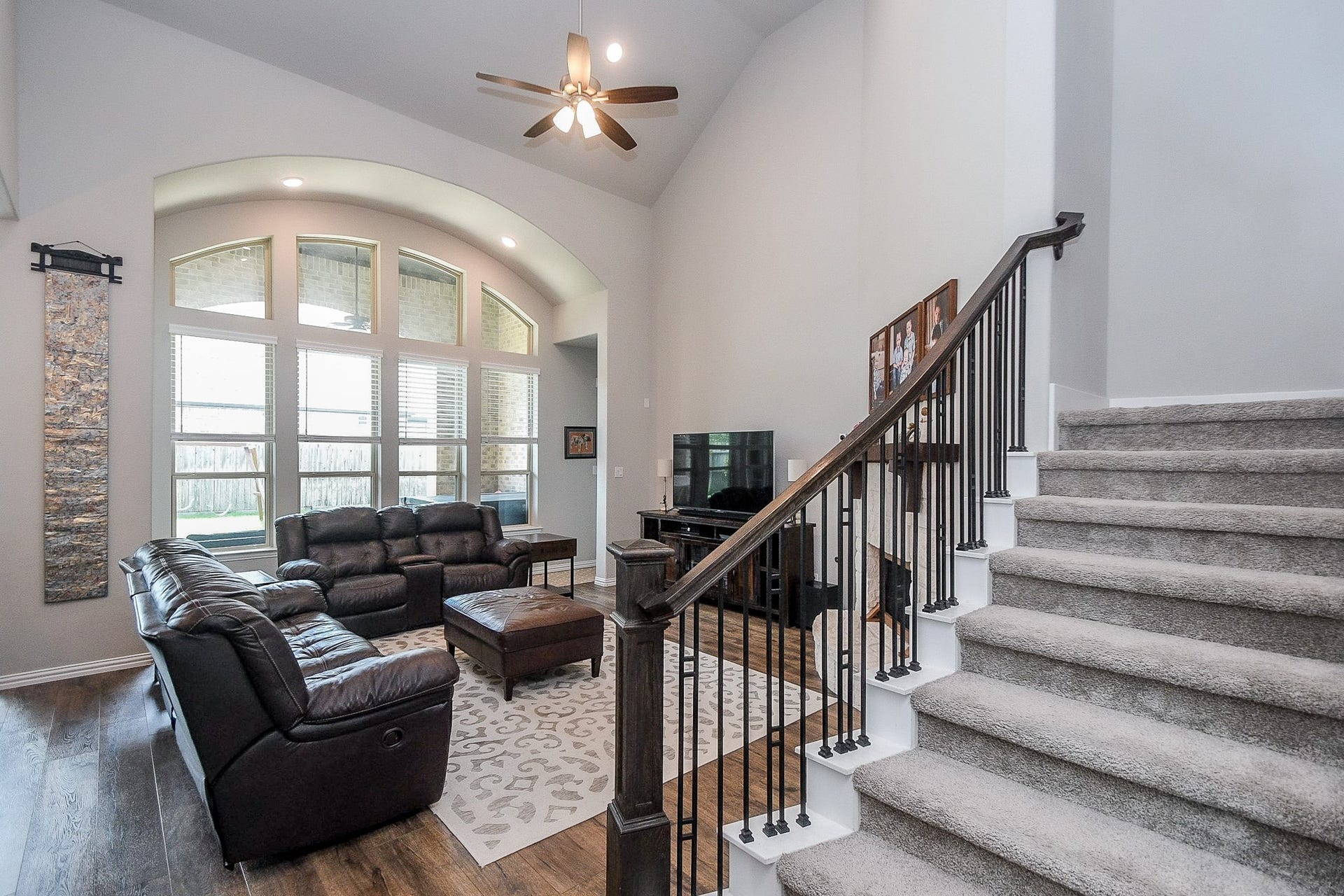2703 Ripe Amber Cup Court, Richmond, TX 77406 Family room with soaring ceiling, curved wall of windows and view toward the second-floor gorgeous wrought-iron staircase.