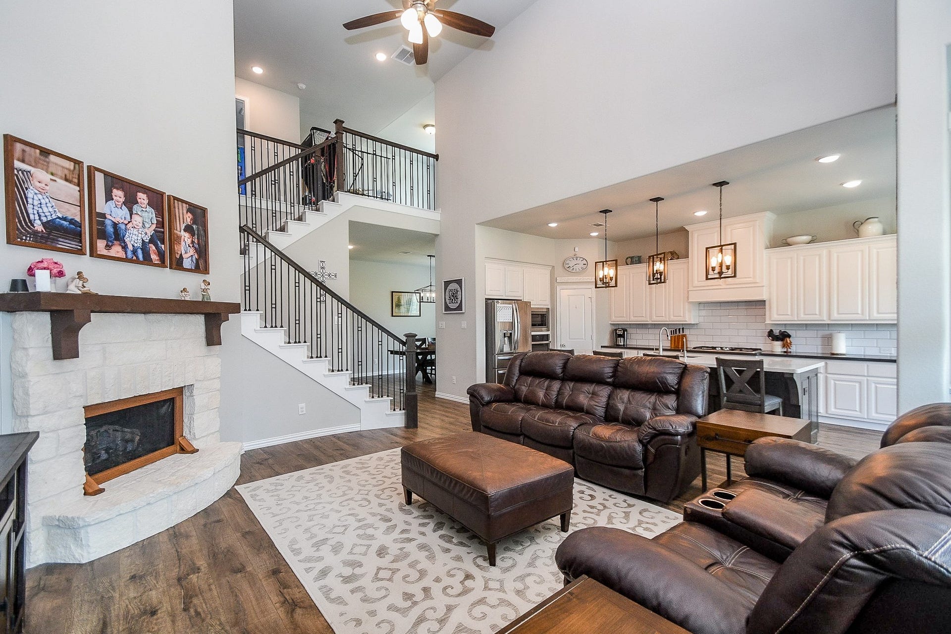 2703 Ripe Amber Cup Court, Richmond, TX 77406 Open family room with stone fireplace, tall ceiling, ceiling fan and direct connection to the kitchen and breakfast area.