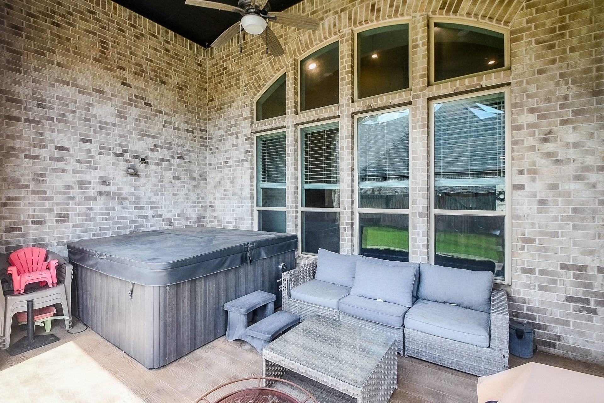 2703 Ripe Amber Cup Court, Richmond, TX 77406 Covered patio includes arched brick openings, backyard views and hot tub area that may remain with the home.
