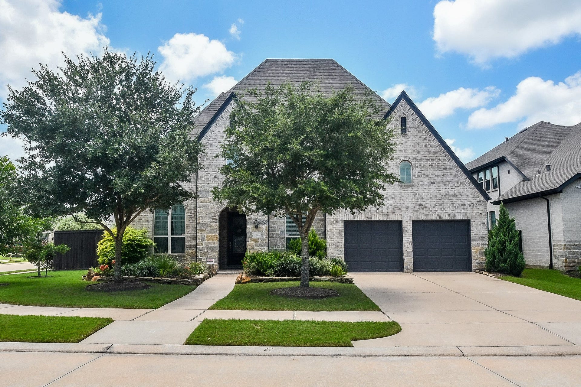 2703 Ripe Amber Cup Court, Richmond, TX 77406 Two-story Highland Homes design with stone-and-brick elevation, mature landscaping and 3-car tandem garage.