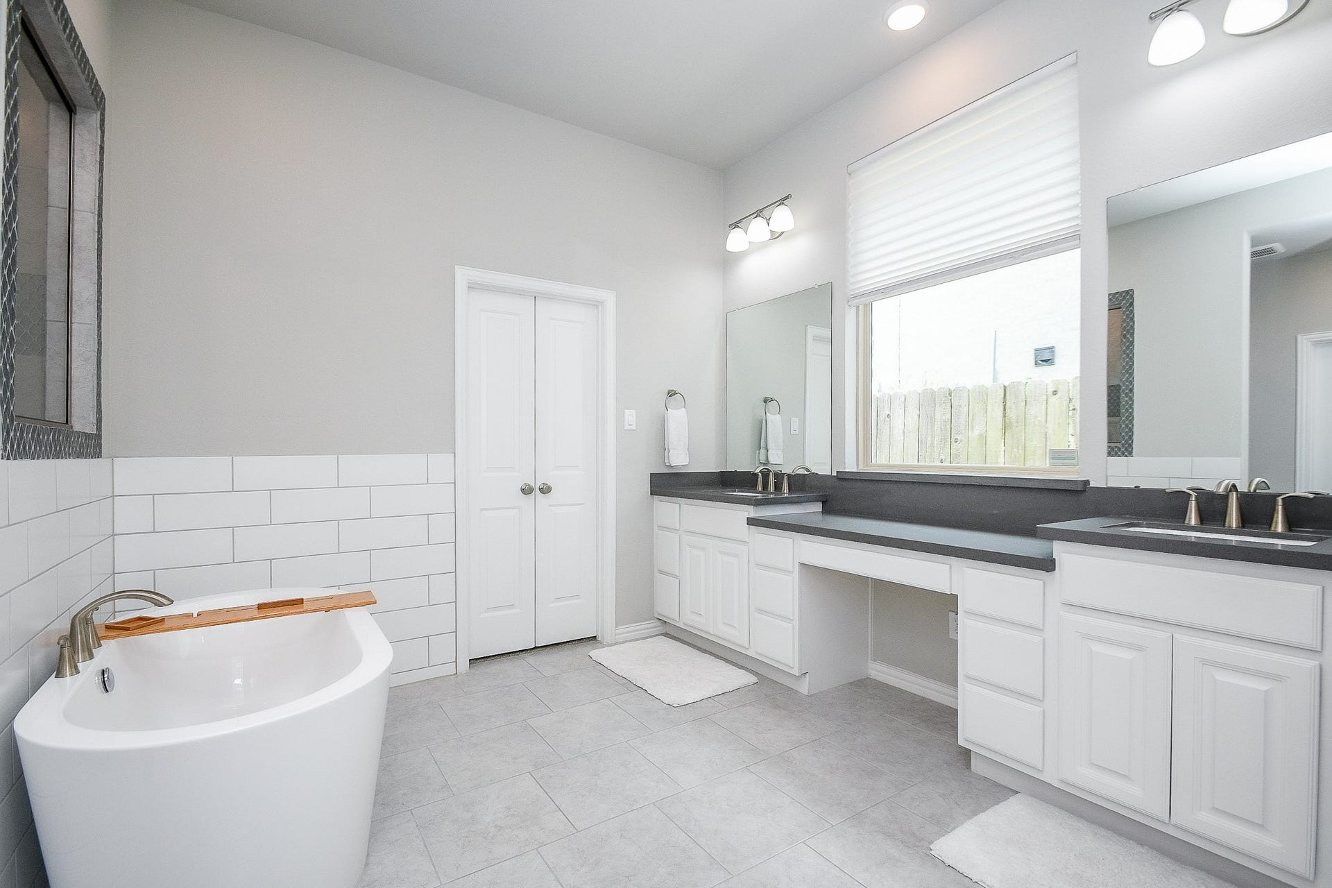 2703 Ripe Amber Cup Court, Richmond, TX 77406 Primary bath with dual sinks, quartz countertops, vanity space, stand-alone soaking tub and walk-in shower beyond the tub wall.