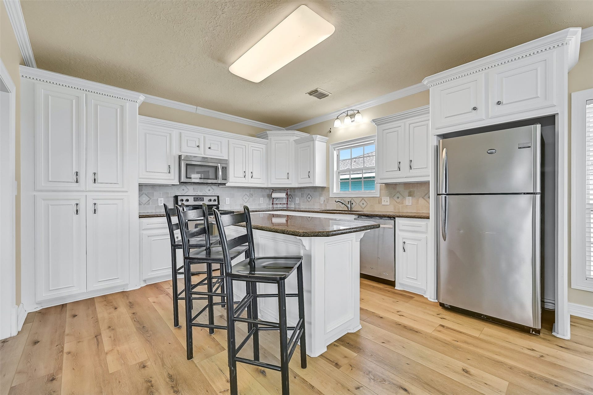 22329 Vista Del Mar, Galveston, TX 77554 The open kitchen features granite countertops and stainless steel appliances.