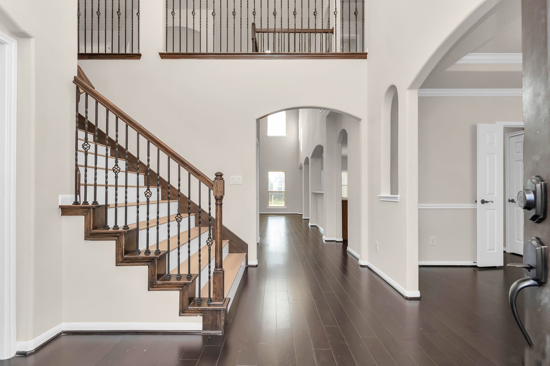 Grand entry with stair case. Wood floor throughout