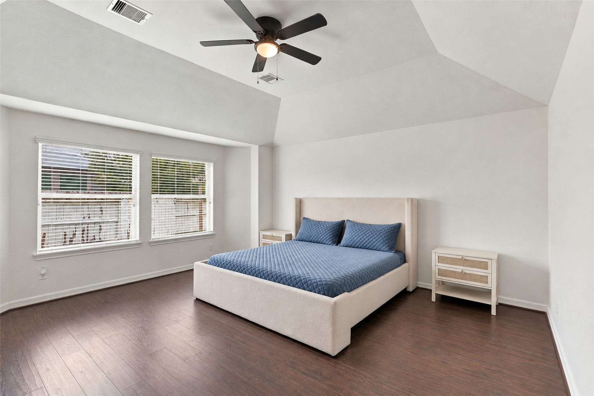 326 Lake Rim Drive, Rosenberg, TX 77469 Primary bedroom with a vaulted ceiling, wood flooring, and two windows.