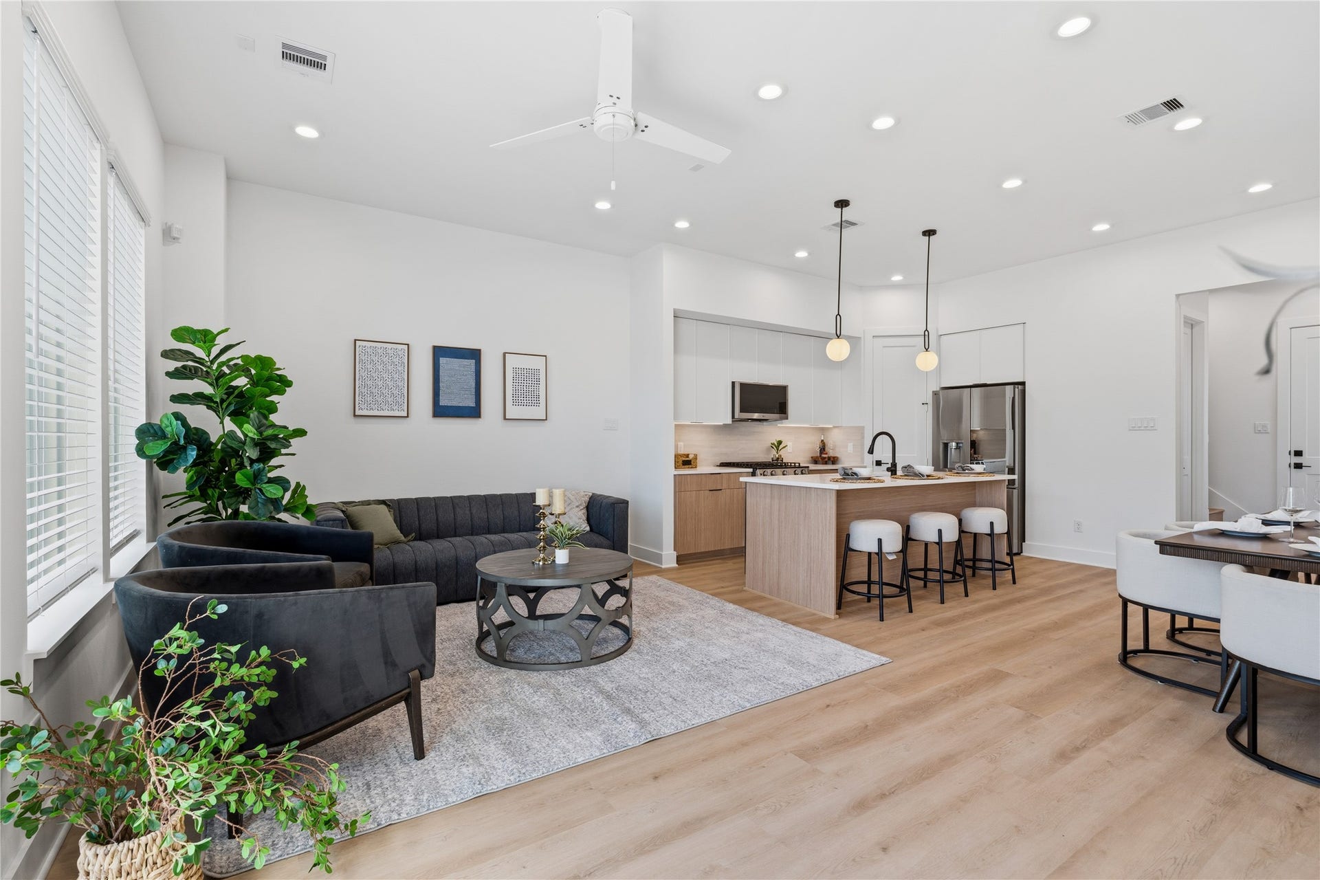 Open-concept single-family living and kitchen area with 10 ceilings, expansive windows, and seamless flow, ideal for entertaining.
