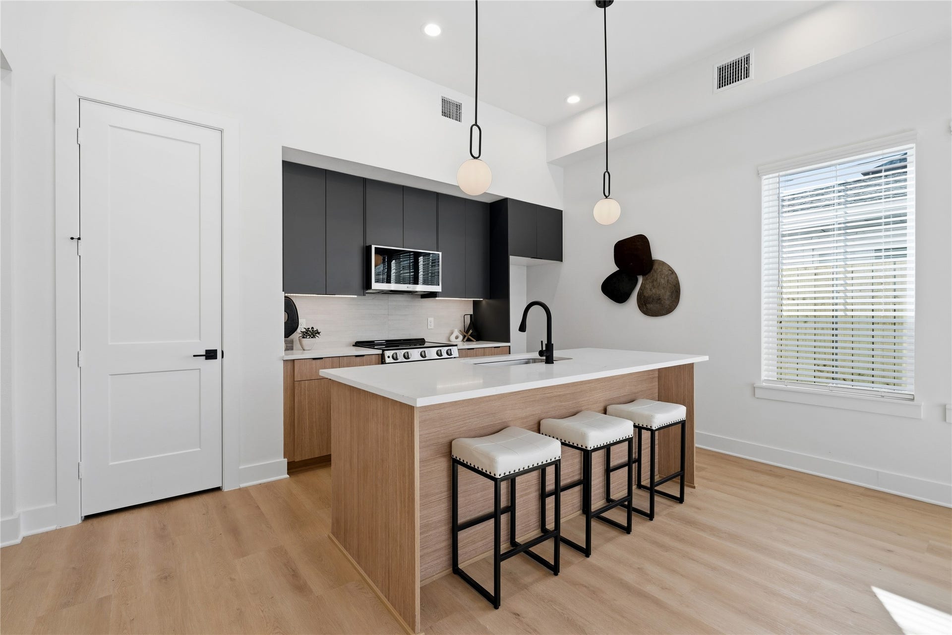 Stylish duplex kitchen with ample cabinetry, clean lines, and a spacious island centerpiece.
