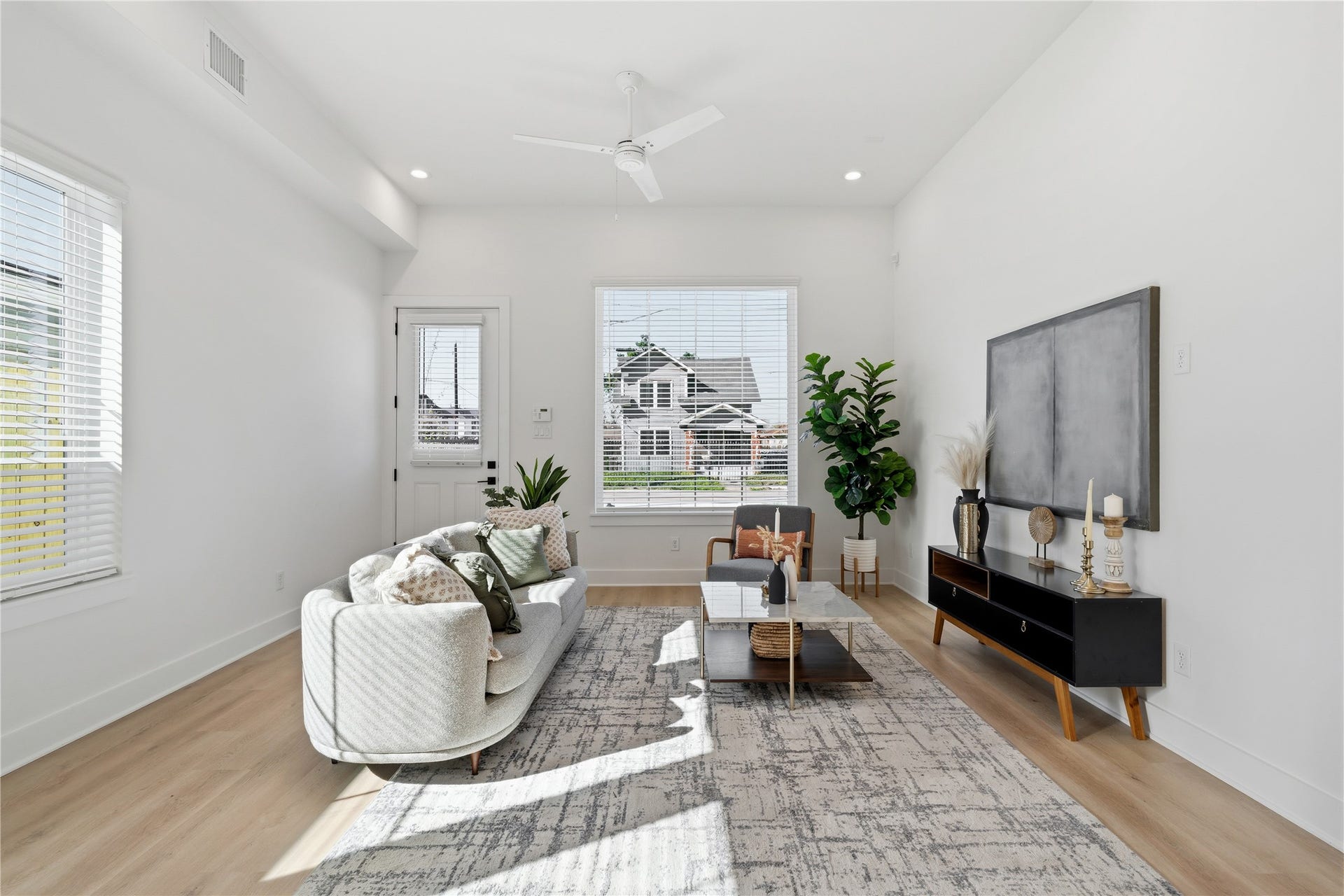 Bright duplex living area with 11 ceilings, oversized windows, and abundant natural light throughout.