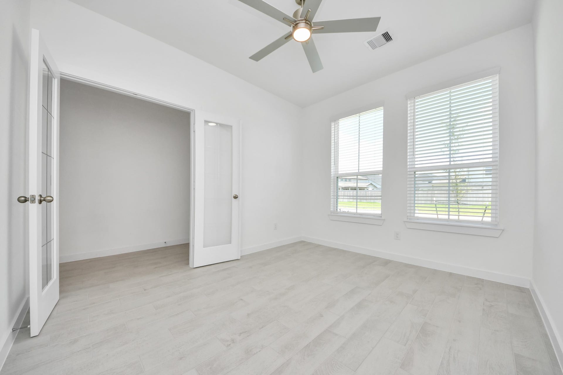 24511 Broad Park Ct, Spring, TX 77373 Experience the perfect blend of sophistication and warmth in this home office, boasting elegant wood-look tile flooring and flooded with natural light from expansive windows and French doors. Sample photo of completed home with similar floor plan. Actual colors and selections may vary.