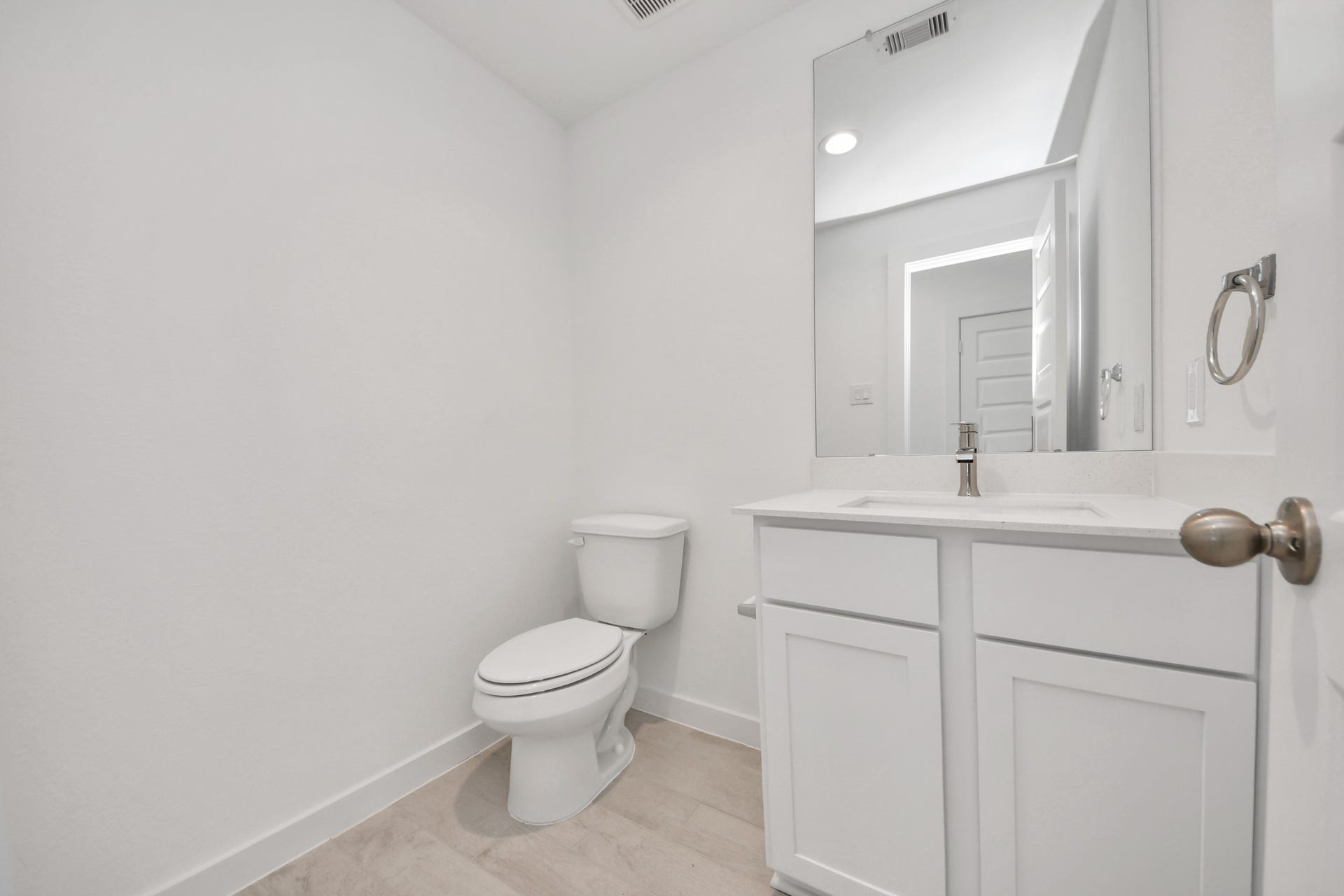 24511 Broad Park Ct, Spring, TX 77373 Sophisticated half bathroom adorned with contemporary finishes. The elegant 5-panel door welcomes you to a space where style meets functionality. Notice the sleek hardware accents that add a touch of modern charm. The vanity boasts light-colored countertops, beautifully complemented by a tasteful vanity light, creating a well-lit and inviting atmosphere. Sample photo of completed home with similar floor plan. Actual colors and selections may vary.