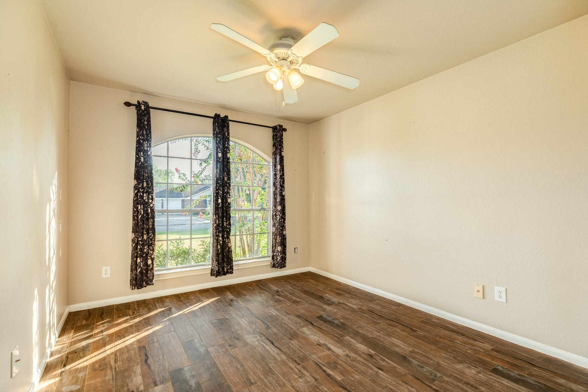 3425 Van Ness Drive, Alvin, TX 77511 Secondary bedroom with a large arched window plus a ceiling fan for comfort.