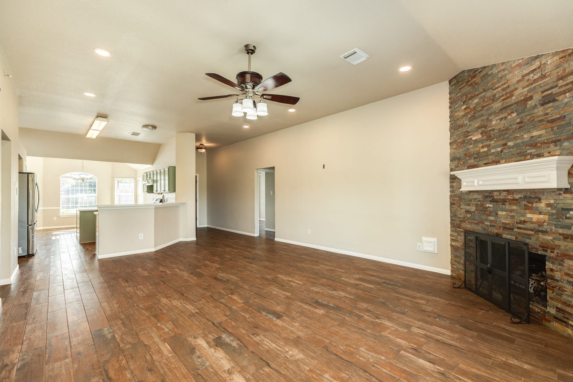 3425 Van Ness Drive, Alvin, TX 77511 Spacious open-concept living area, and a modern kitchen with a breakfast bar, all illuminated by abundant natural light.