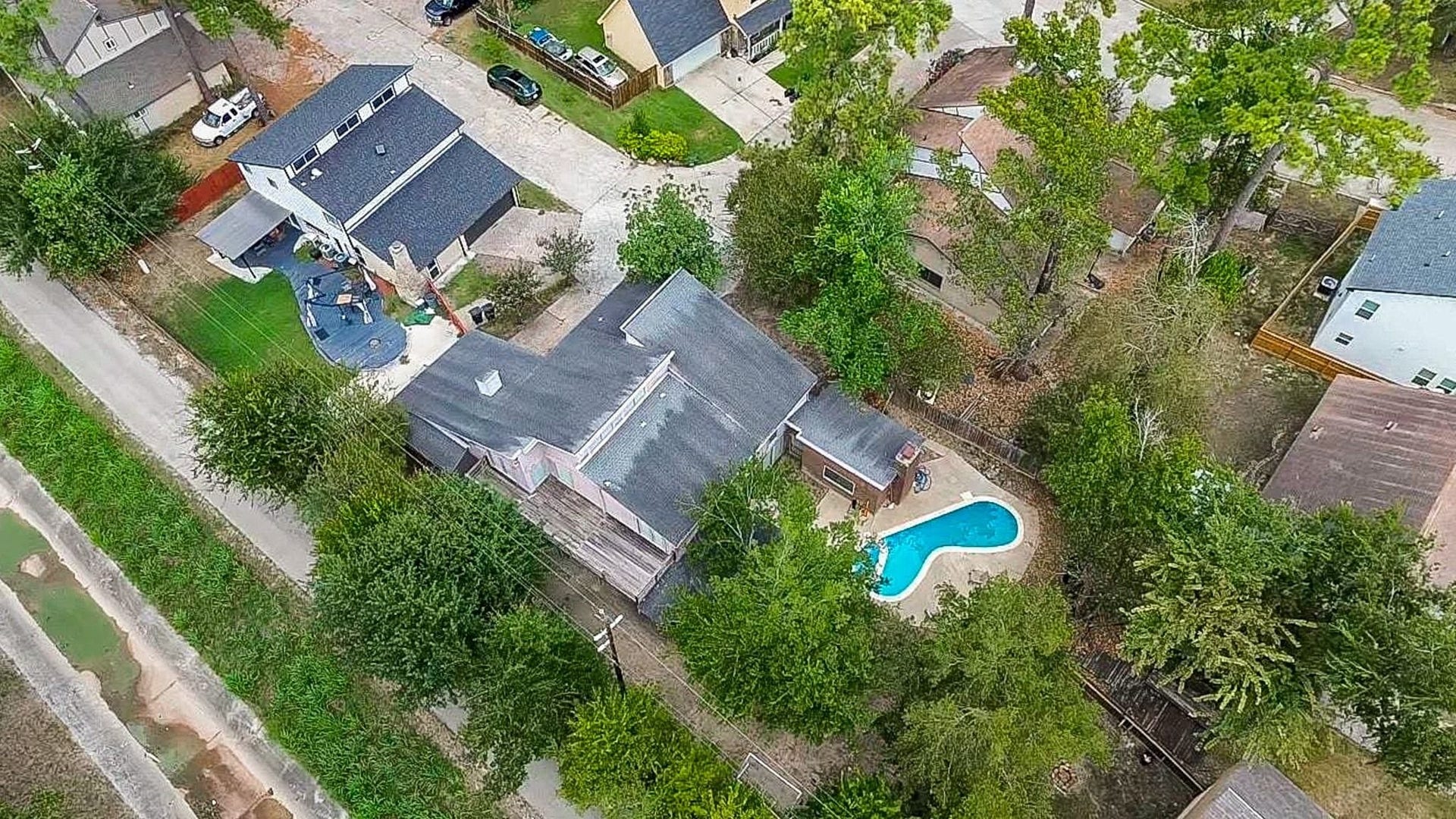 17821 S Cypress Villas Drive, Spring, TX 77379 Aerial view showcasing the tree-shaded backyard with pool and patio, fenced yard, and the homes placementon the neighborhoods second-largest lot (per seller).