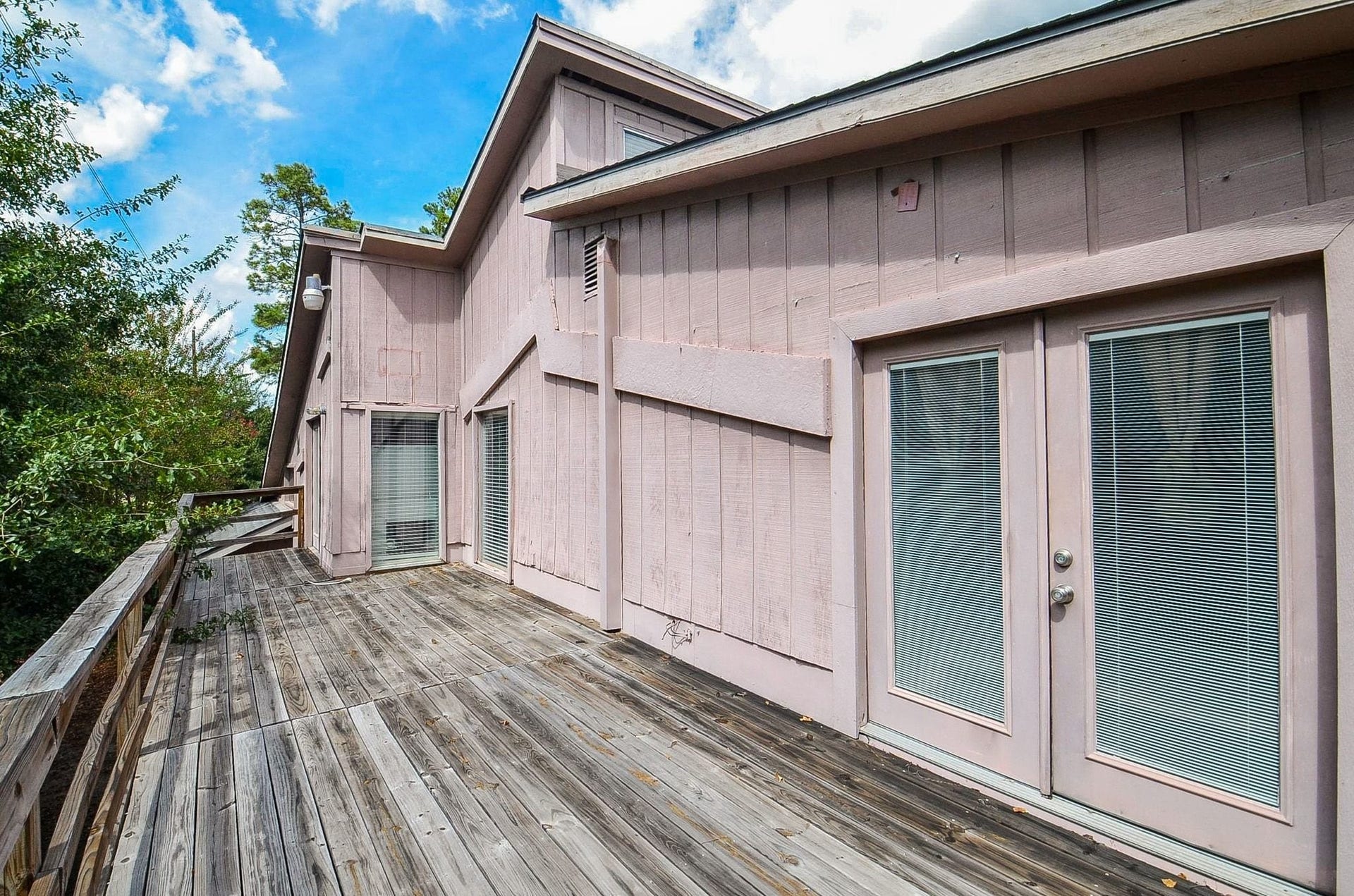 17821 S Cypress Villas Drive, Spring, TX 77379 Upper-level patio deckperfect for morning coffee or stargazing. Connected to the lower level by an exterior staircase with a door at the base that resembles an attic door.
