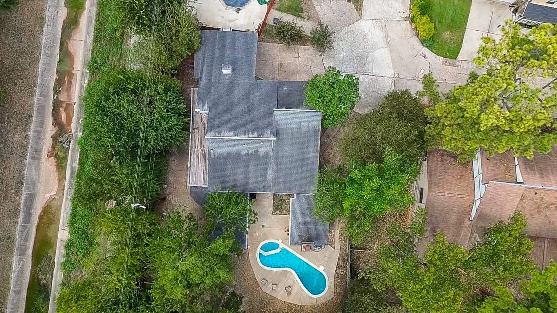 17821 S Cypress Villas Drive, Spring, TX 77379 Aerial view of the property showcasing the oversized, tree-shaded lot, extra-long driveway with ample parking, multiple garage bays, and a fenced side yard.