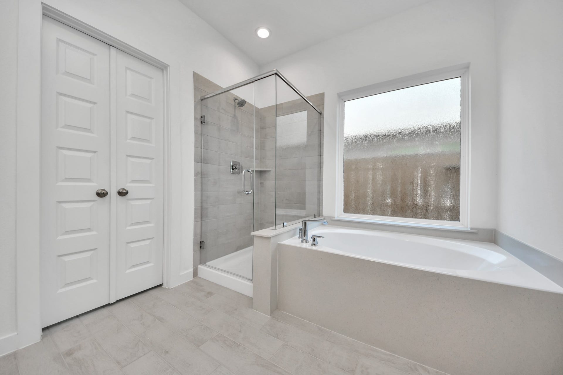 2203 Demeter Place, Fresno, TX 77545 Escape to a spa-like oasis in this primary bathroom. Enjoy a walk-in shower with tile surround, a separate garden tub with custom detailing, and an elegant vanity featuring light countertops, modern hardware, and beautiful recessed lights. Experience luxury and relaxation in every detail. Sample photo of completed home with similar floor plan. Actual colors and selections may vary.
