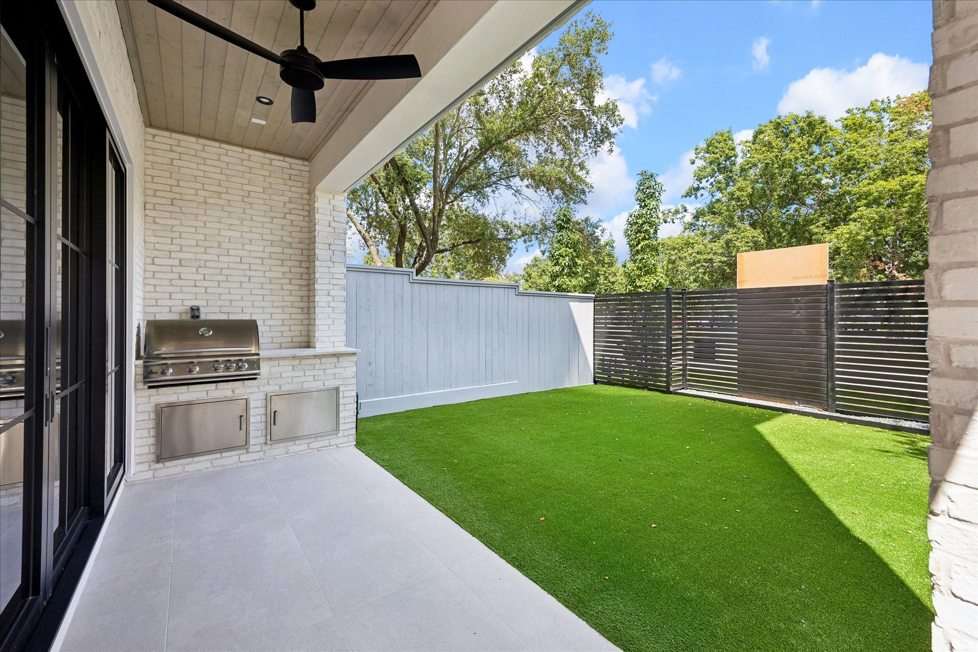 6303 Rodrigo Street, #A, Houston, TX 77007 Covered summer kitchen features a built-in grill, cabinetry, ceiling fan and views of the backyard.