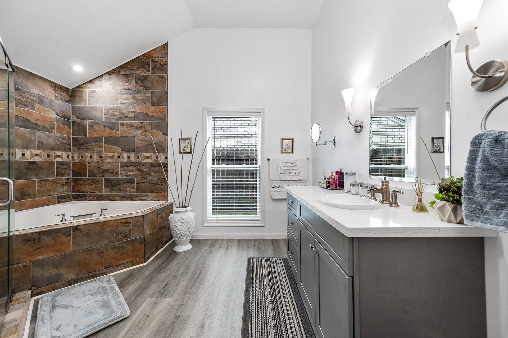 8914 Sunny Point Drive, Spring, TX 77379 This primary bathroom features a
walk-in shower, separate garden tub,
dark stained cabinets with light
countertops, and sleek modern
finishes!