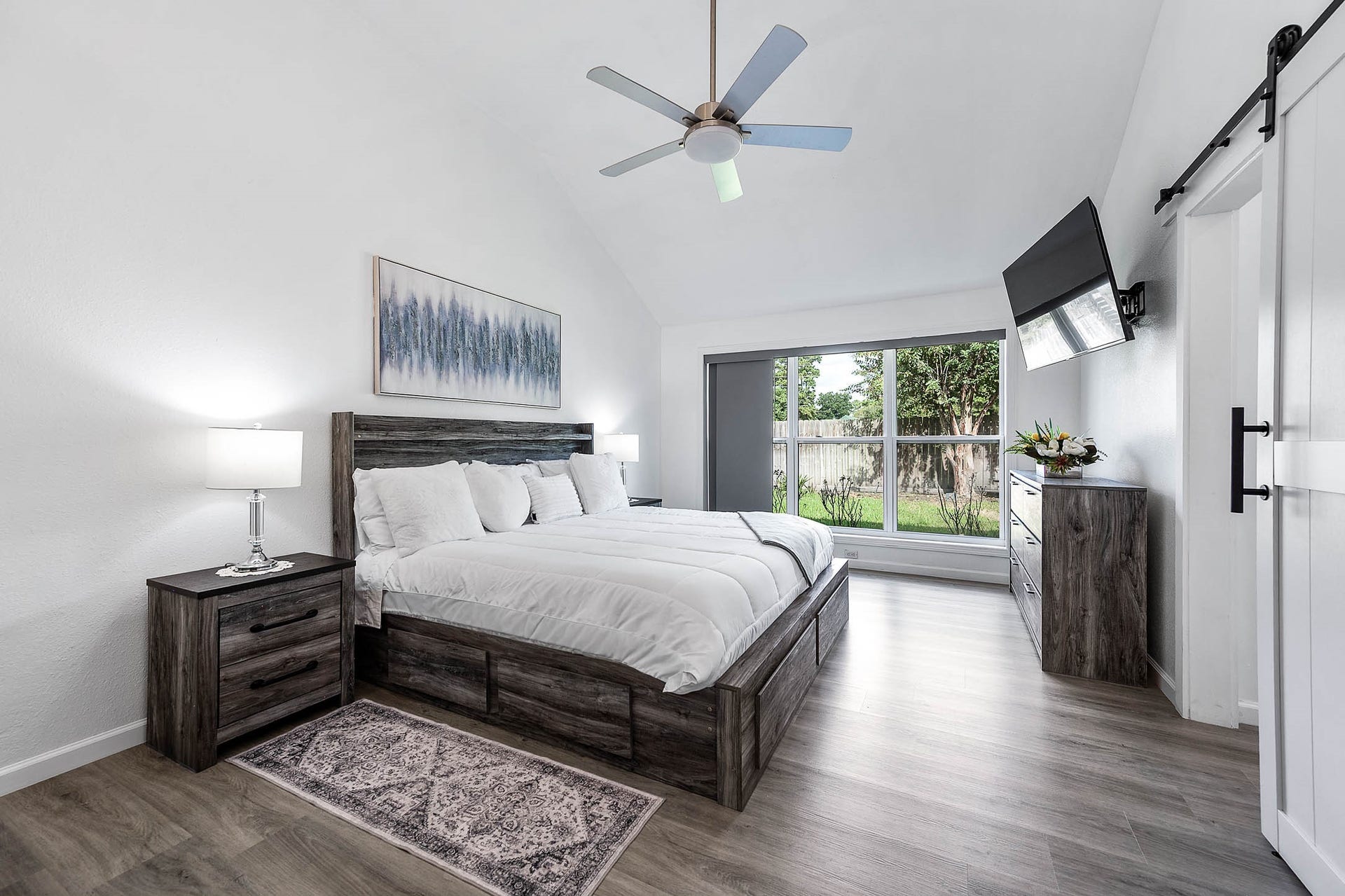 8914 Sunny Point Drive, Spring, TX 77379 This primary suite greets you with
high ceilings, ceiling fan with lighting,
and large windows with blinds
allowing in natural light to brighten up
this spacious primary bedroom.