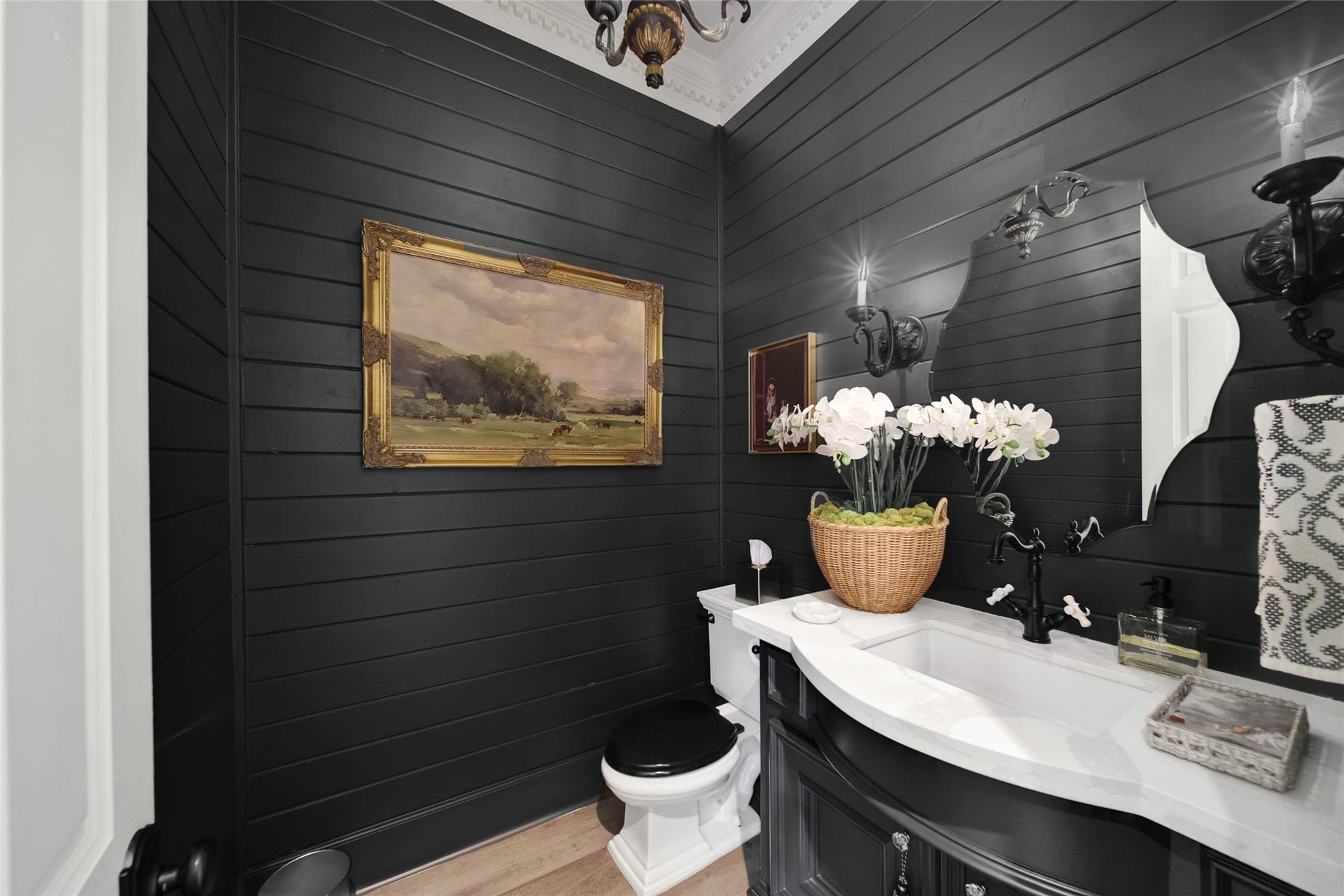 39 W Old Sterling Circle, The Woodlands, TX 77382 Elegantly styled powder room featuring dark paneling, sophisticated fixtures, and tasteful decor for a touch of luxury.