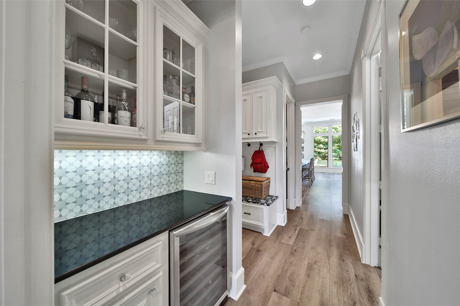 39 W Old Sterling Circle, The Woodlands, TX 77382 Luxurious butlers pantry hallway with elegant cabinetry, wine storage, and stylish backsplash.