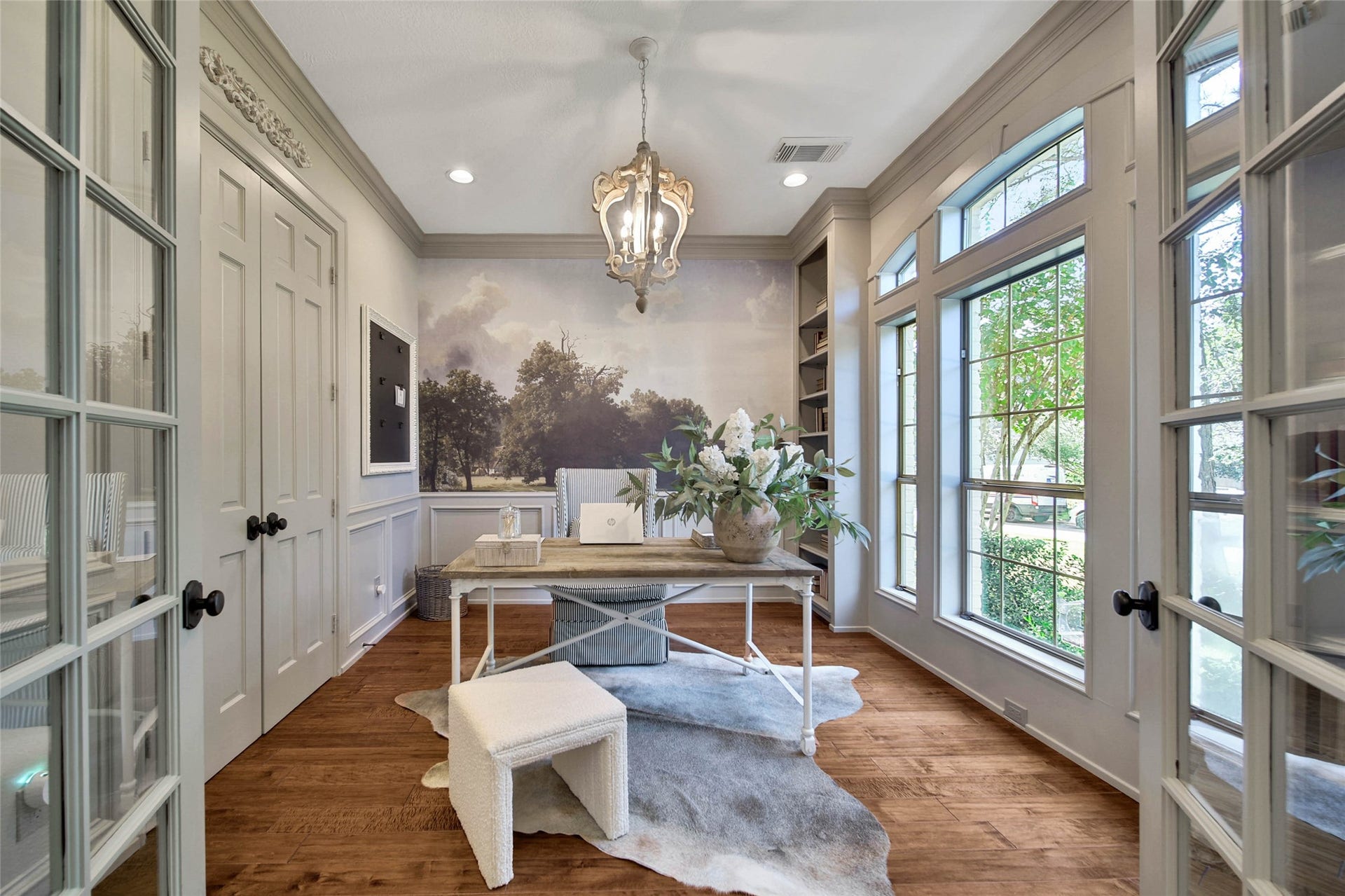 39 W Old Sterling Circle, The Woodlands, TX 77382 Elegant study bathed in natural light features floor-to-ceiling windows, and exquisite wood flooring, creating an inspiring workspace.