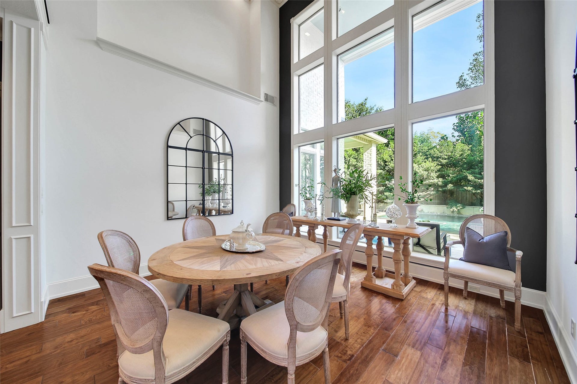 39 W Old Sterling Circle, The Woodlands, TX 77382 Bright and inviting dining room featuring soaring windows that flood the space with natural light and offer serene garden views.