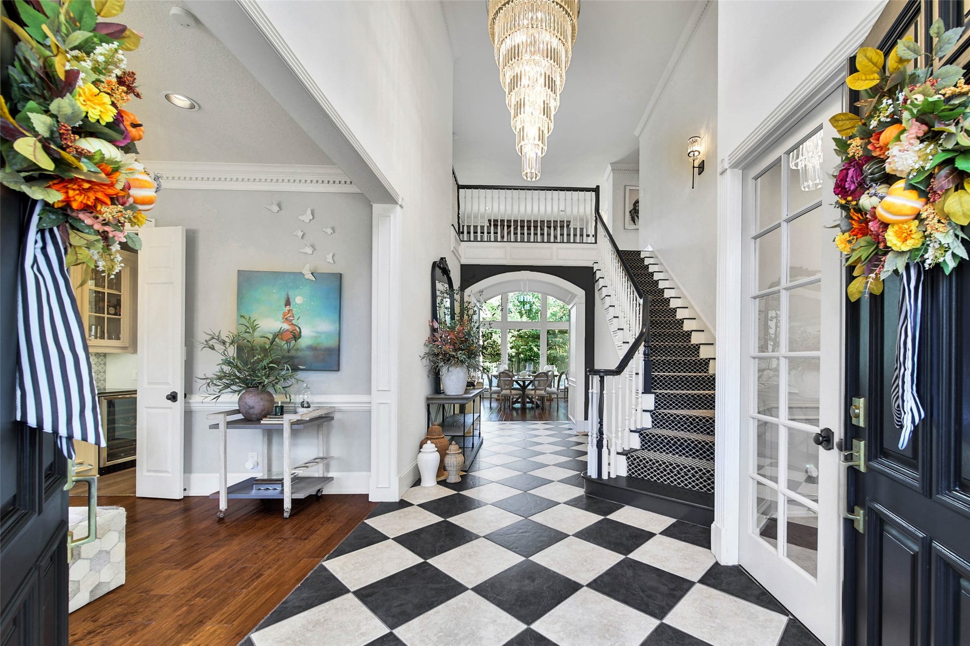 39 W Old Sterling Circle, The Woodlands, TX 77382 Stunning entryway featuring elegant black and white checkered flooring, a grand chandelier, and a striking staircase leading to the second floor. Decorative accents and abundant natural light create a welcoming ambiance.