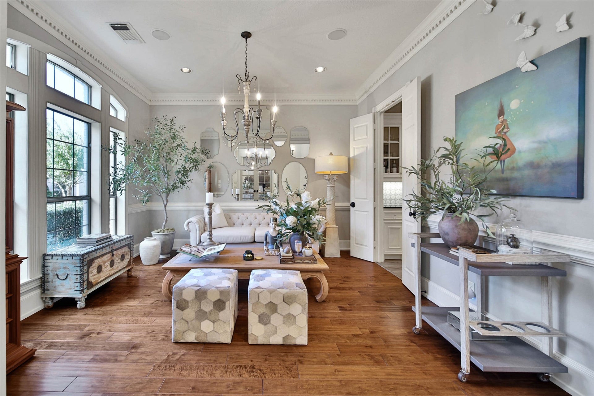 39 W Old Sterling Circle, The Woodlands, TX 77382 Formal living room with abundant natural light, featuring a stylish chandelier, sophisticated decor, and rich hardwood floors.