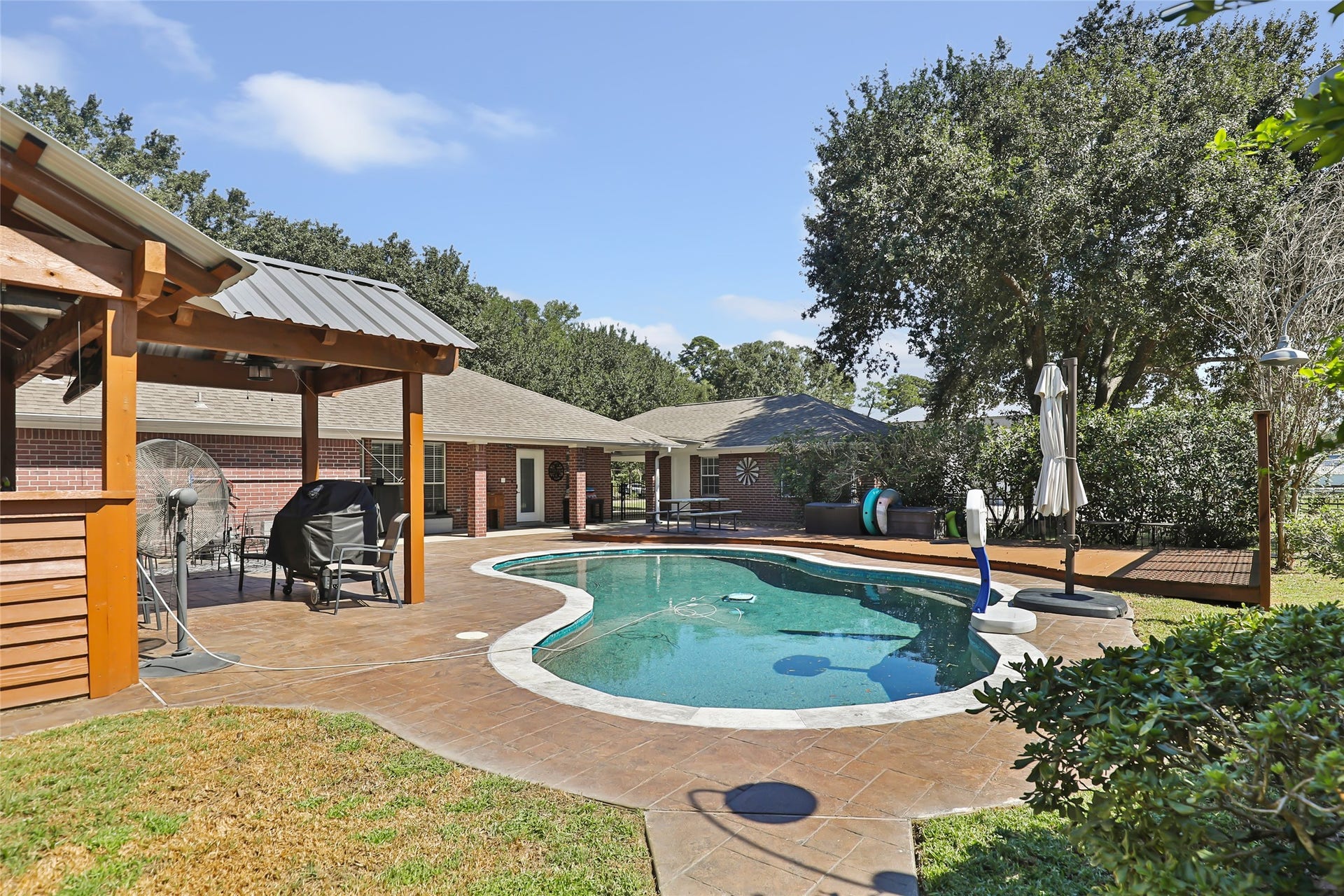 25107 Goodson Road, Splendora, TX 77372 Relax in your private backyard oasis featuring a sparkling pool, spacious patio, and a charming gazebo perfect for outdoor gatherings.