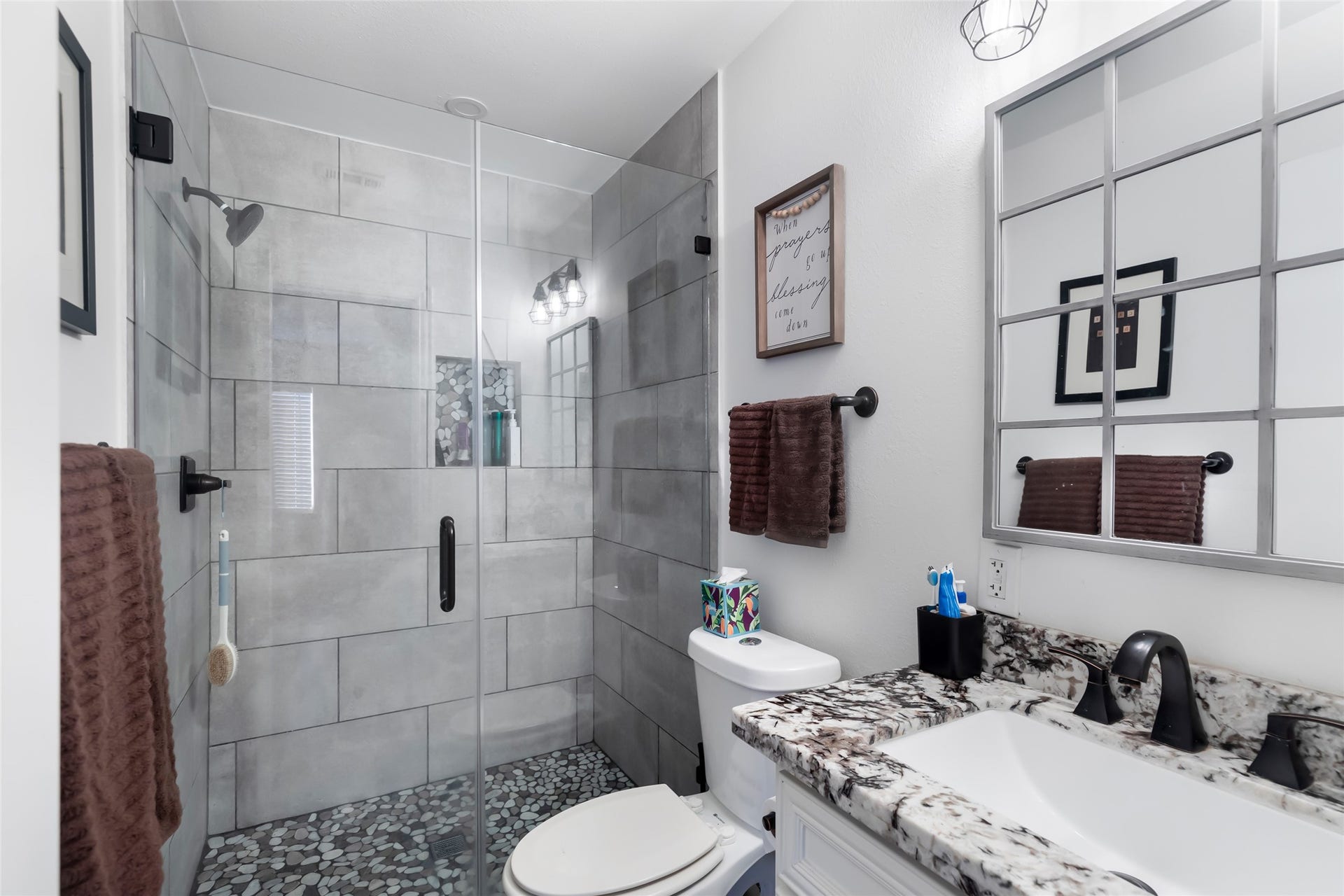 25107 Goodson Road, Splendora, TX 77372 Modern bathroom featuring a sleek glass-enclosed shower with stylish tilework, complemented by a granite countertop and contemporary fixtures.