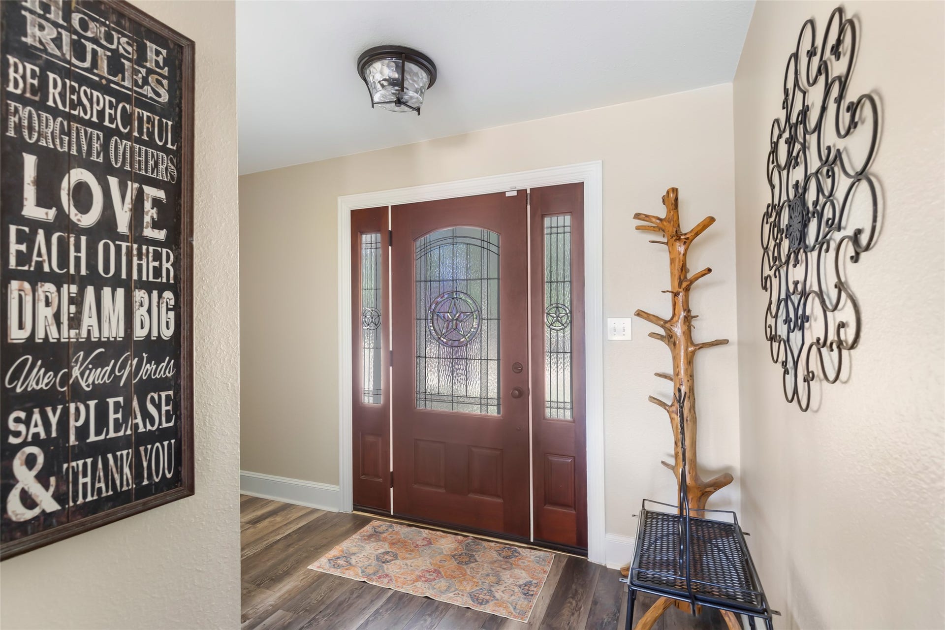 25107 Goodson Road, Splendora, TX 77372 Inviting entryway featuring elegant double doors with decorative glass panels, warm wood flooring, and stylish wall accents.