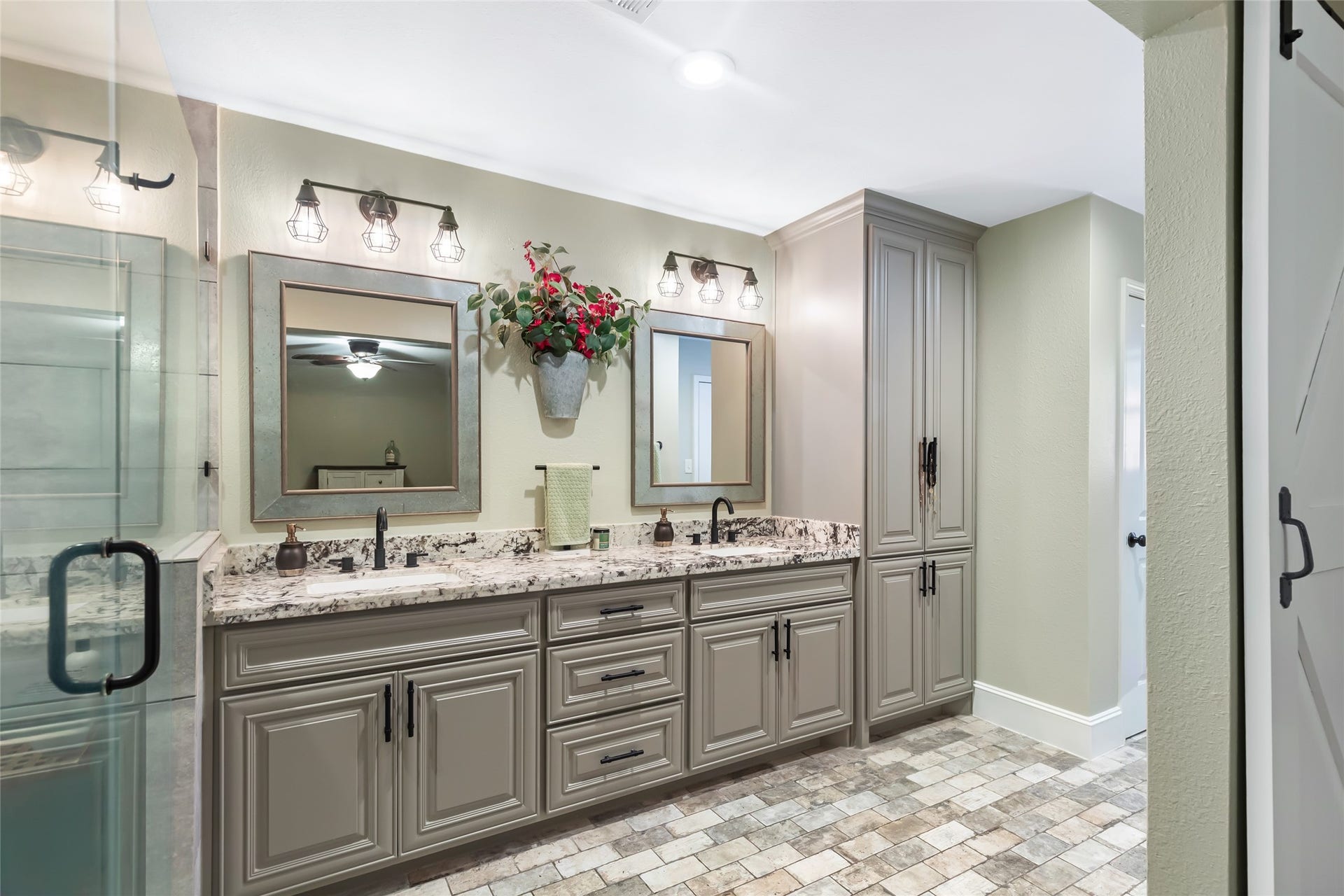 25107 Goodson Road, Splendora, TX 77372 Elegant bathroom featuring a double vanity with granite countertops, stylish lighting, and ample storage space, complemented by a chic tile floor.