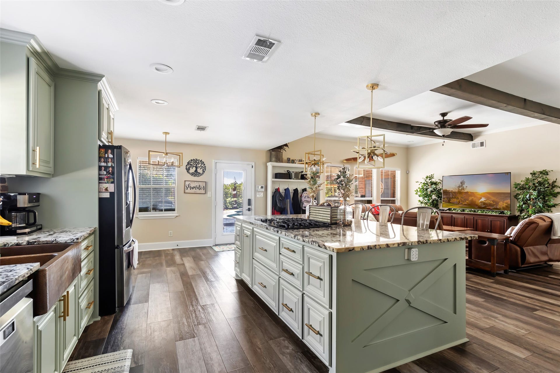 25107 Goodson Road, Splendora, TX 77372 Spacious open-concept kitchen and living area featuring a large island with granite countertops, modern appliances, and cozy seating, perfect for entertaining.
